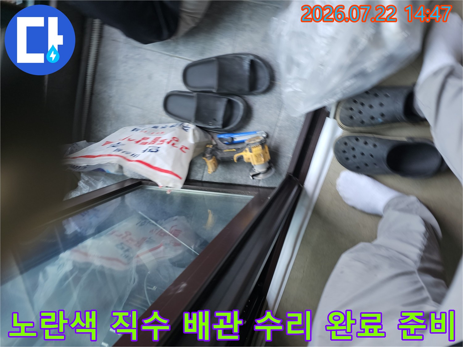 파손된 노란색 직수 배관을 교체하기 위해 도구와 자재를 배치한 모습