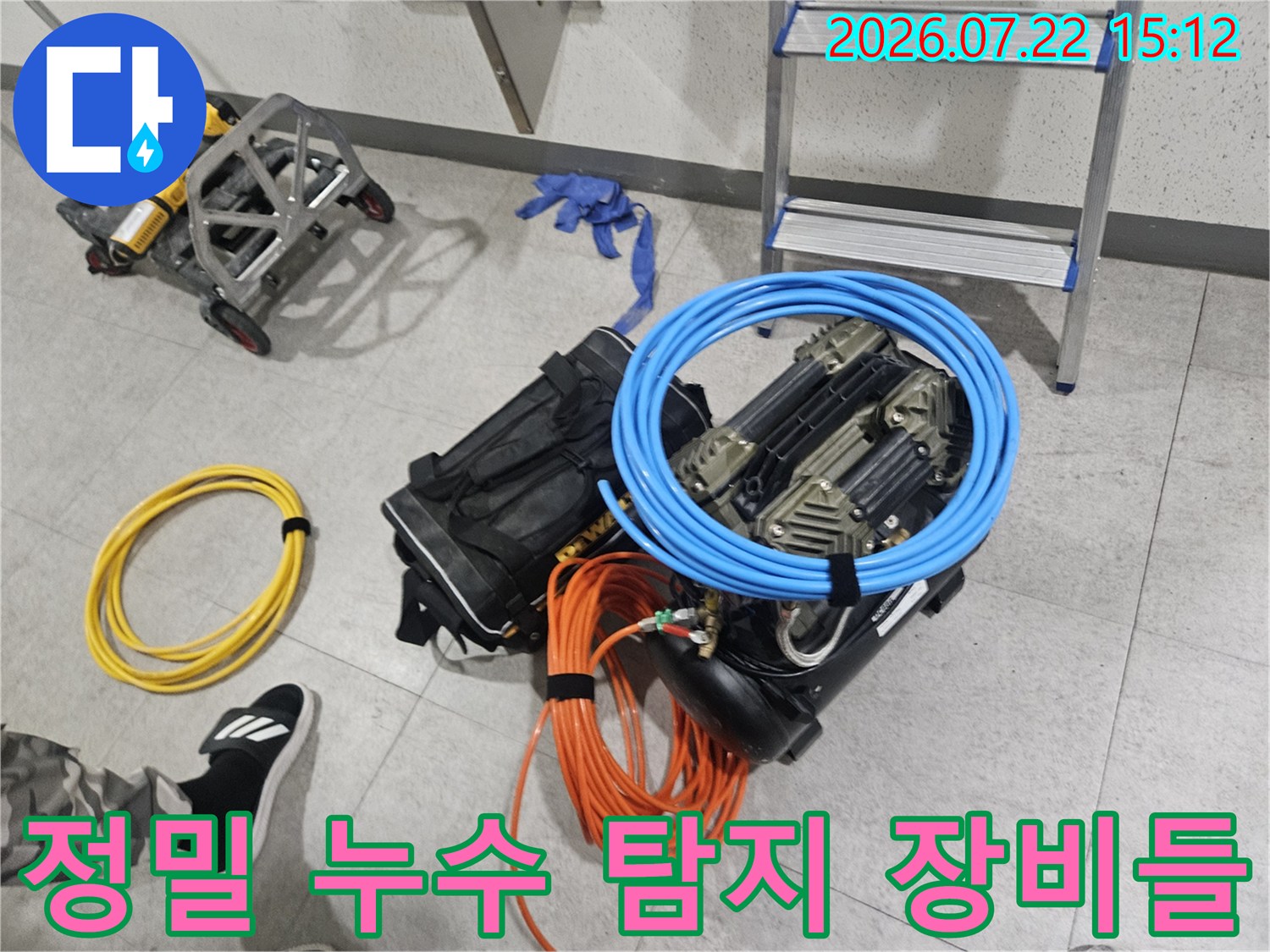 바닥에 놓인 파란색 호스와 오렌지색 전선 그리고 정밀 누수 탐지기 세트