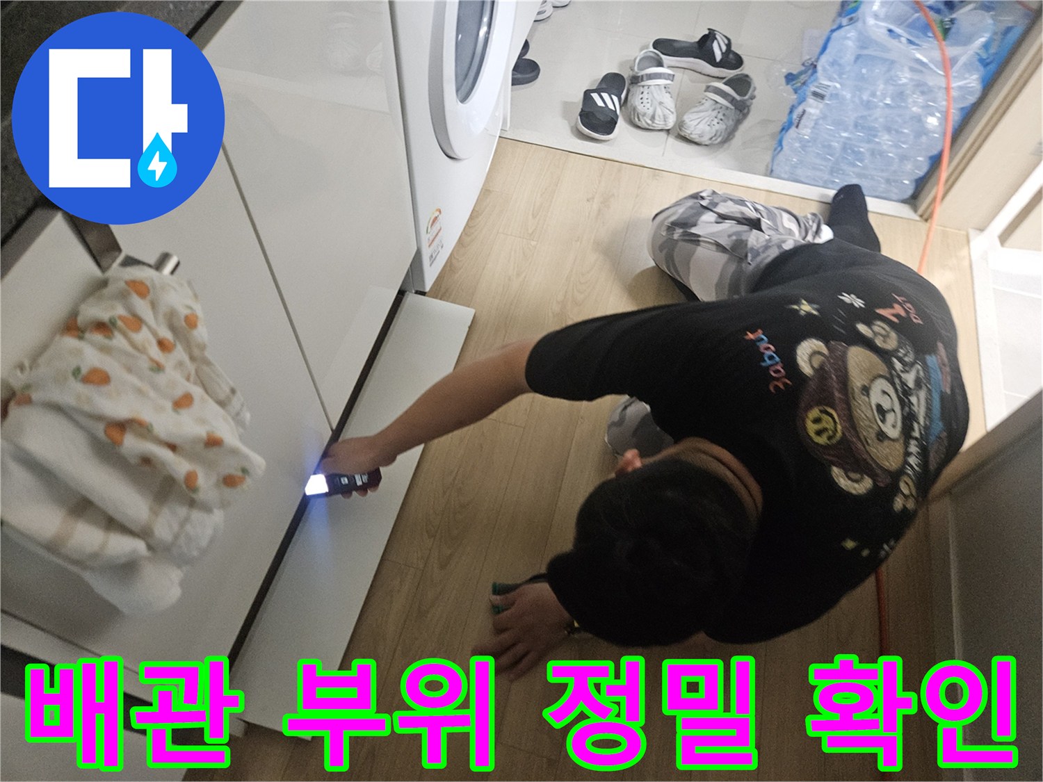 싱크대-밑-배관-주변을-손전등으로-조사하는-엔지니어의-모습