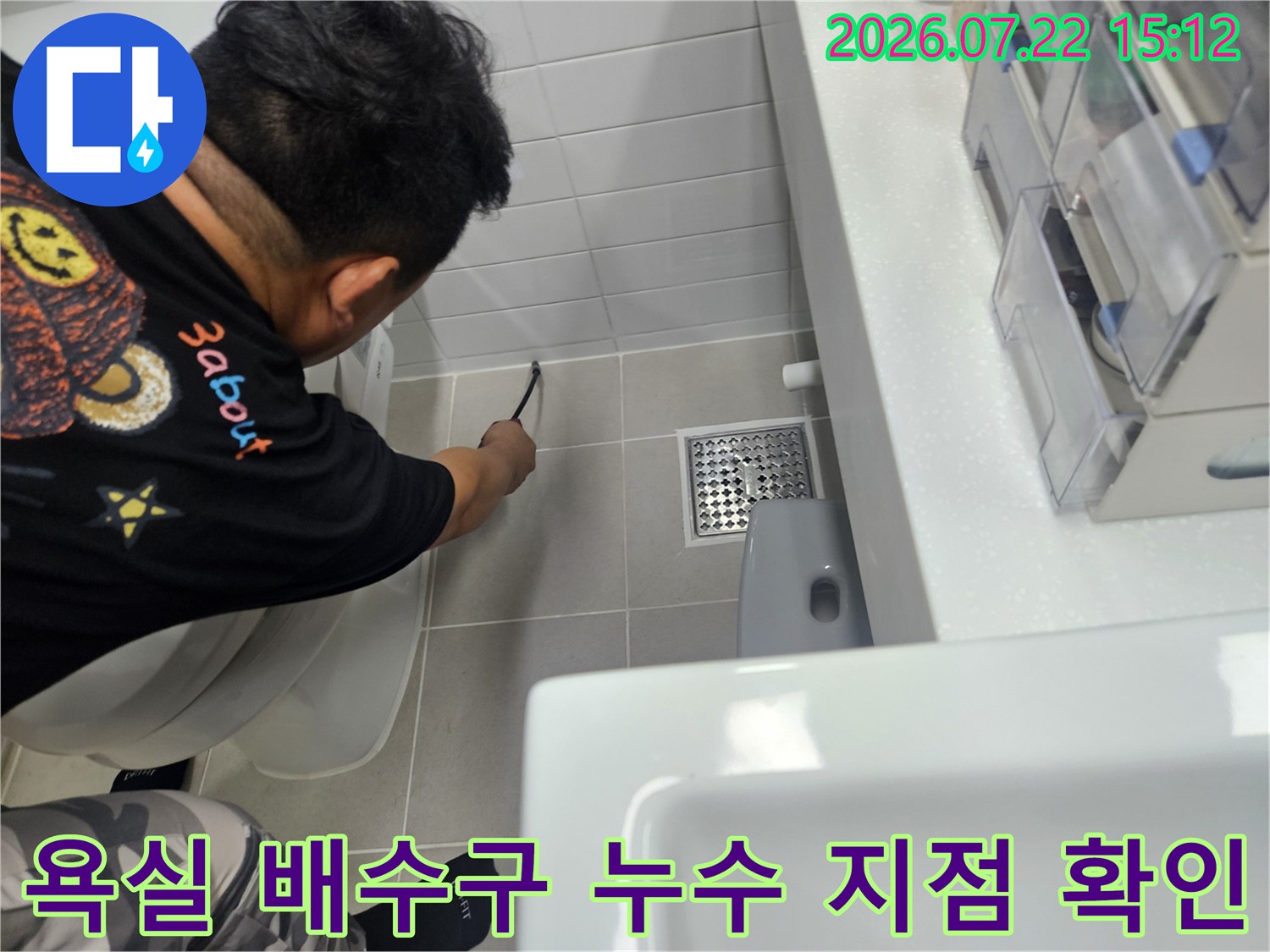 흰색 욕실 타일 위-금속제 유가 주변을-꼼꼼하게 검사 중인 작업자