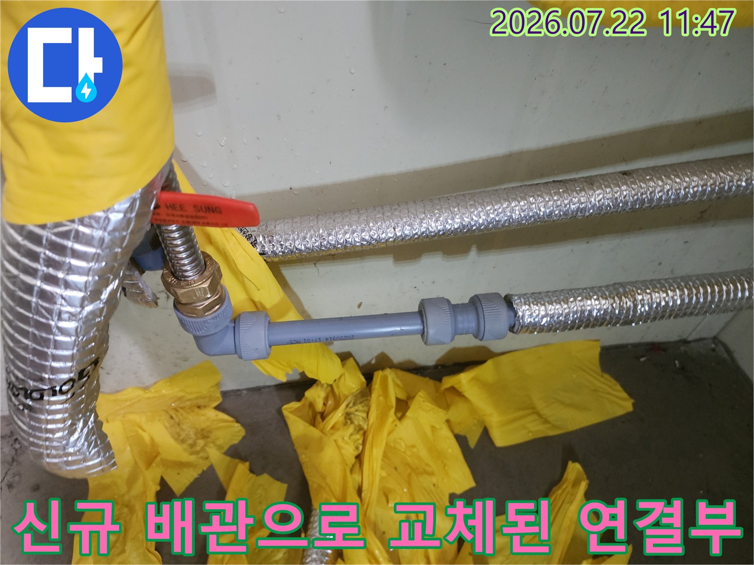 은색 보온재가 씌워진 배관과 그 사이에 설치된 회색 플라스틱 배관의 모습