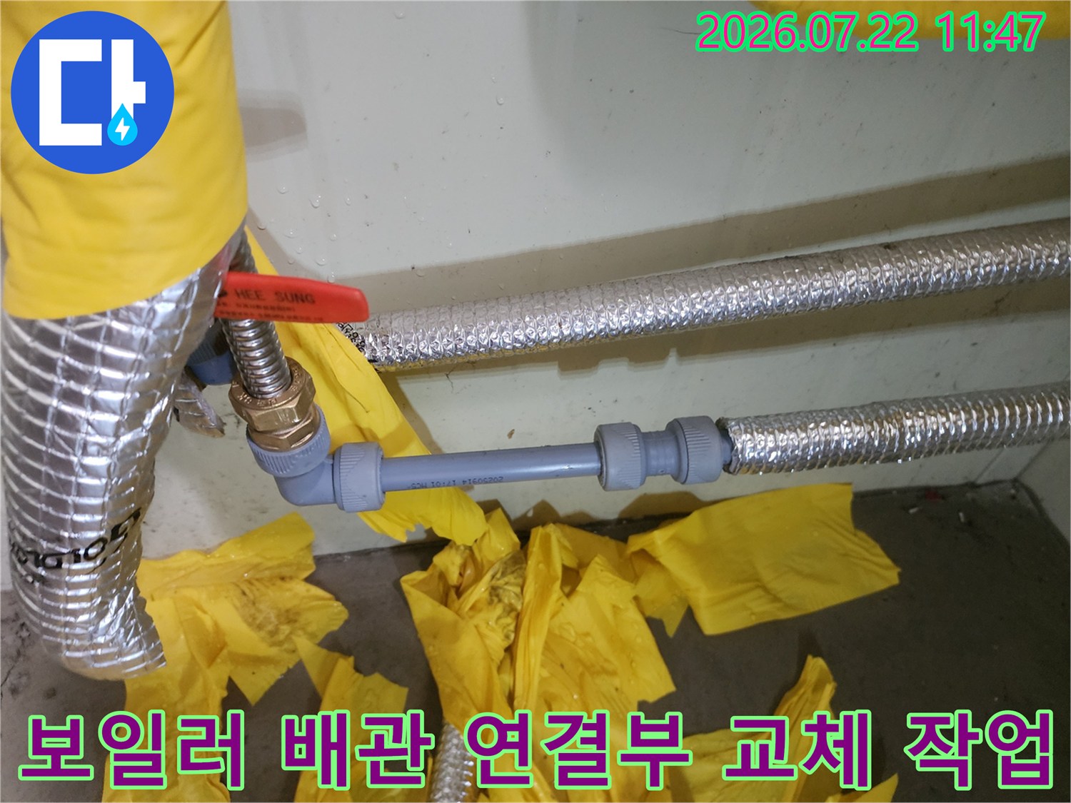 회색 PEX 배관과 금속 부속이 연결된 보일러 하단 배관 라인-은색 보온재 마감 상태