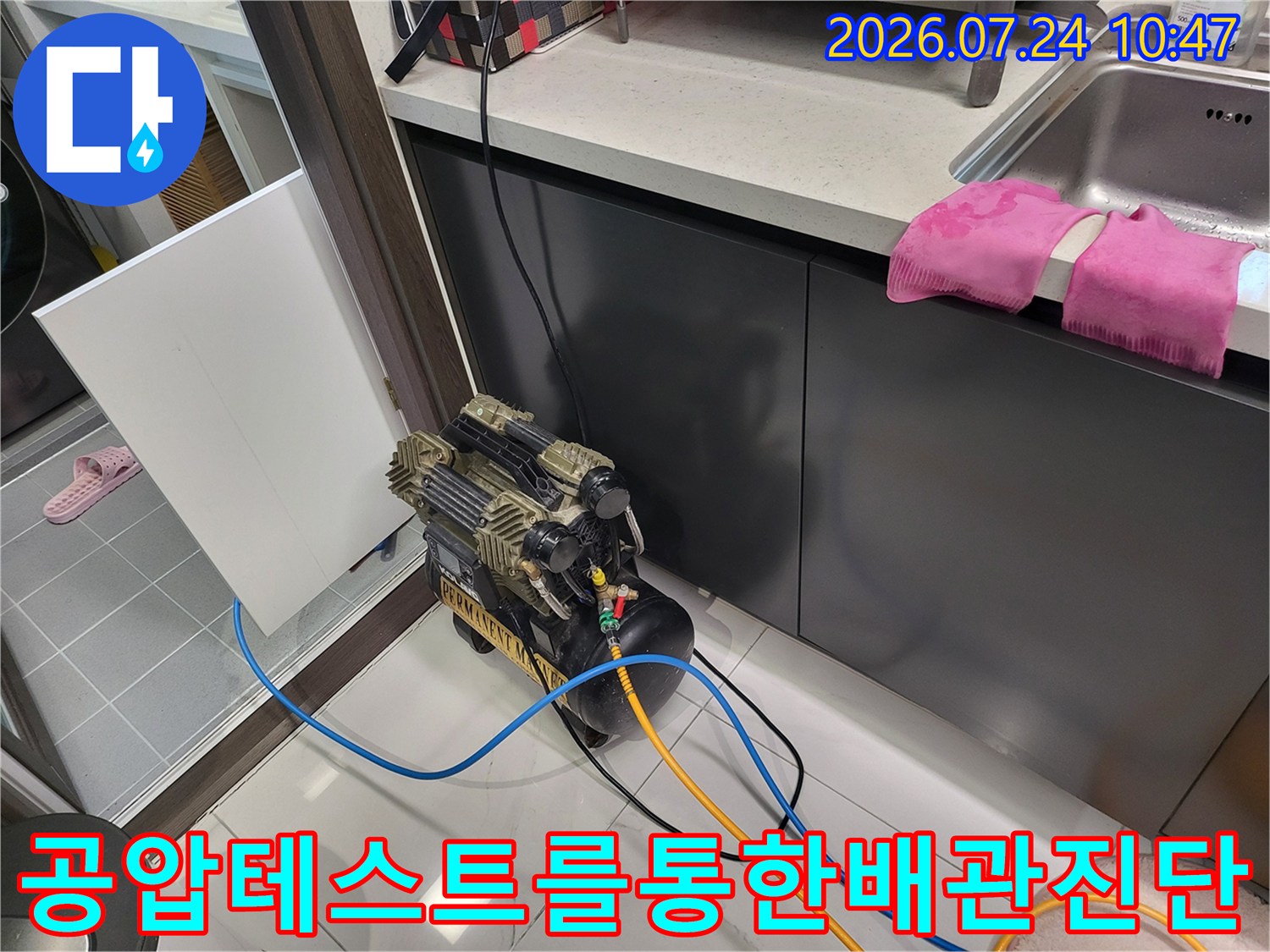 싱크대 하부 배관에 장비를 연결하여 압력을 체크하며 누수 여부를 판단하는 모습