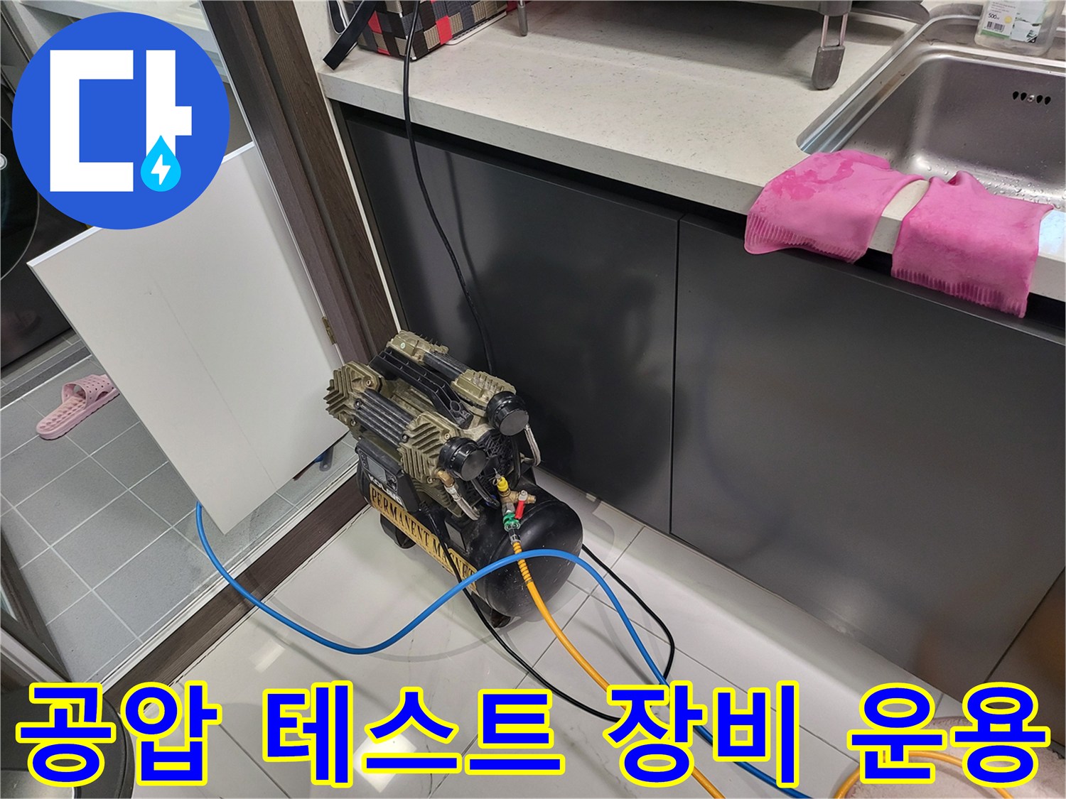 싱크대 하부 배수관에 연결된 공압 테스트기 및 호스