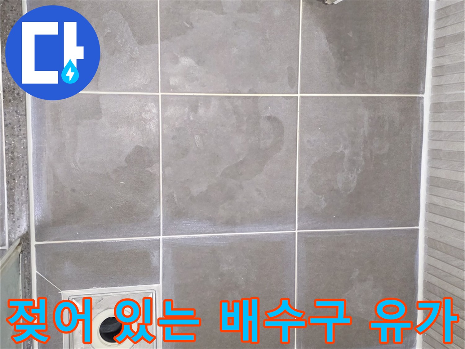 습기가 가득한 욕실 배수구와 타일 마감 부위 상세 사진