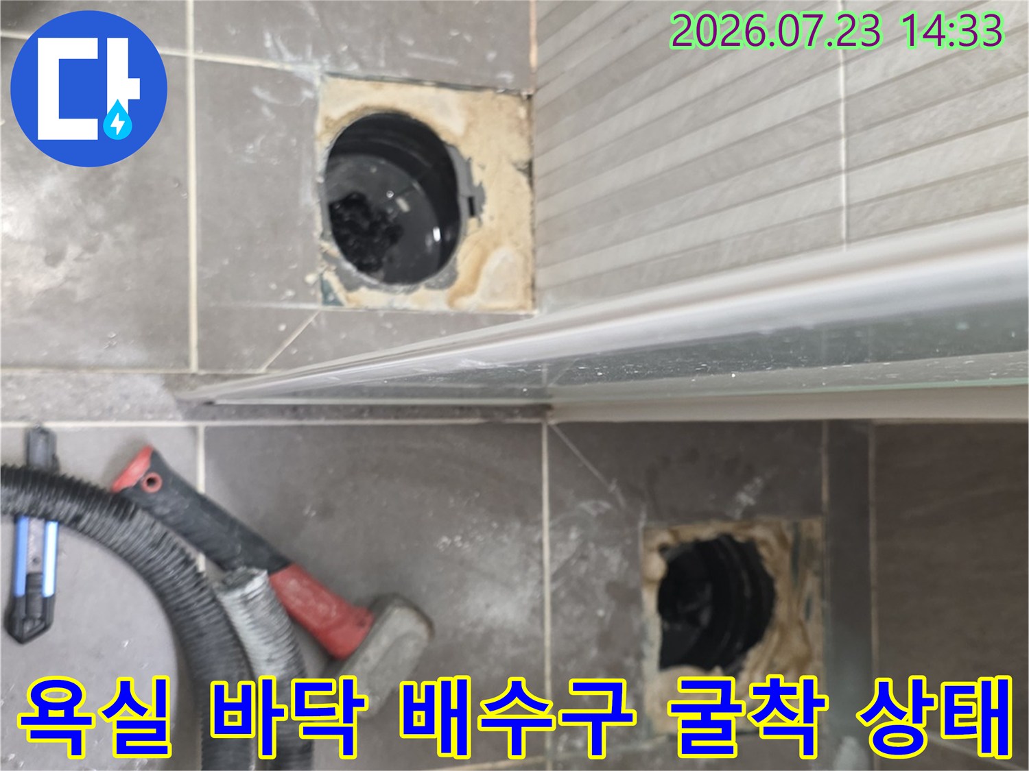 화장실-타일-바닥을-제거하고-드러난-두-곳의-배수관-입구-모습