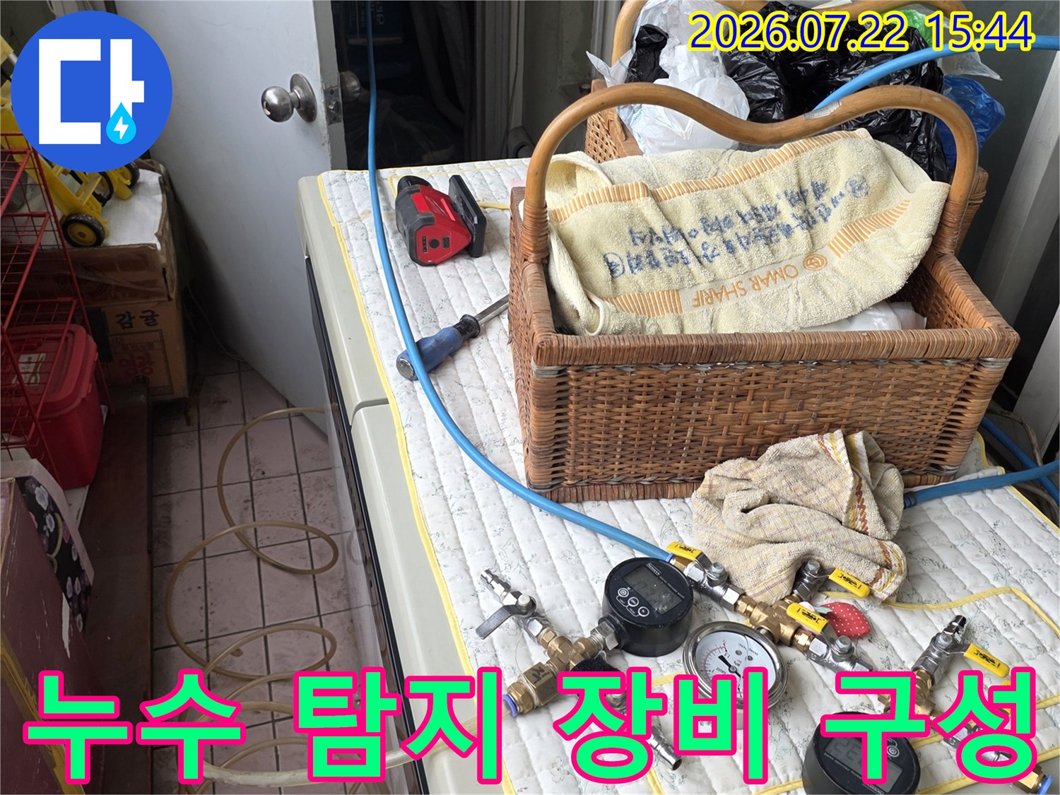 디지털 압력계와 호스 그리고 공구들이 놓여 있는 누수 진단 현장