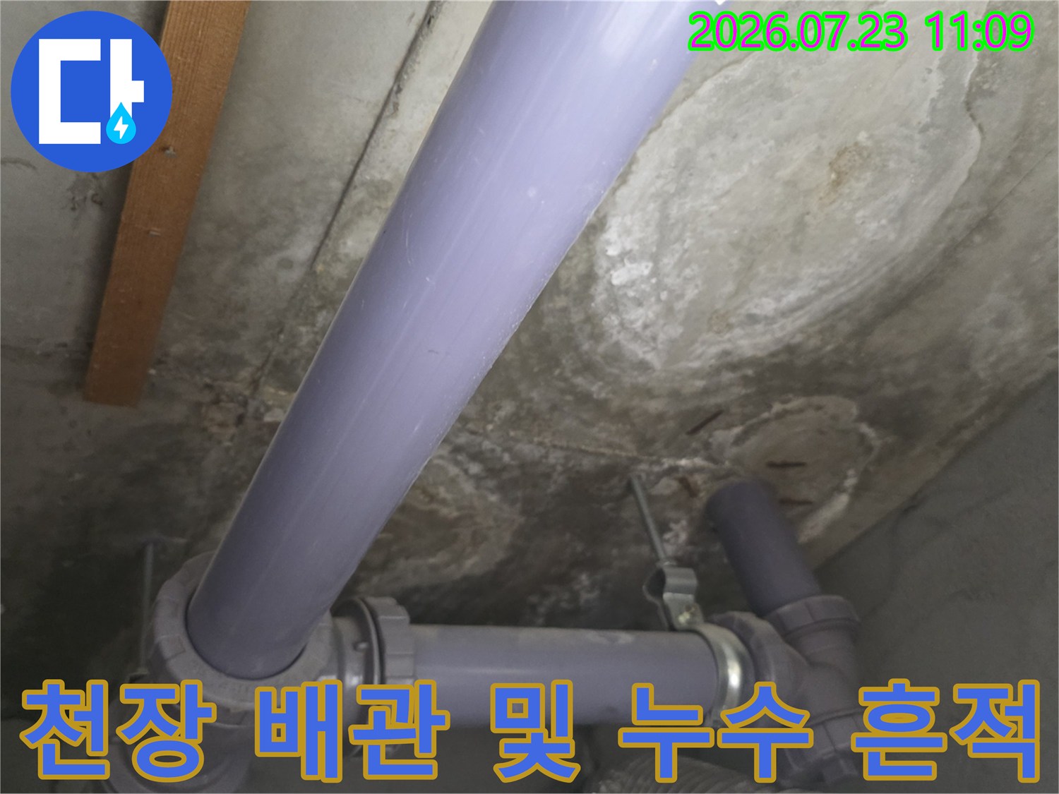 아파트 천장 내부의 보라색 배관과 콘크리트 슬래브에 생긴 물 얼룩 모습