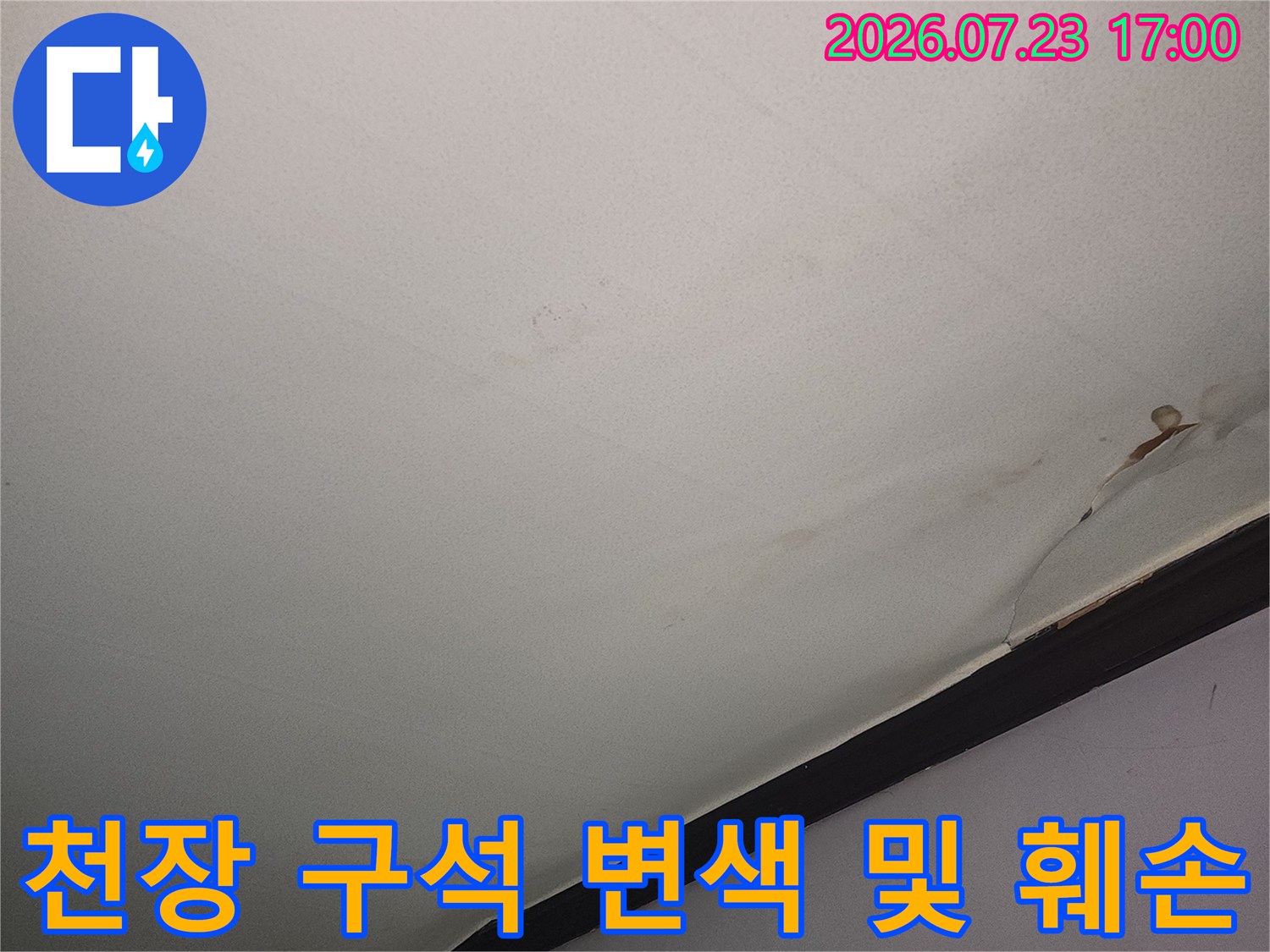 흰색 천장 벽면 모서리에 갈색 누수 얼룩이 넓게 퍼진 상태-사진