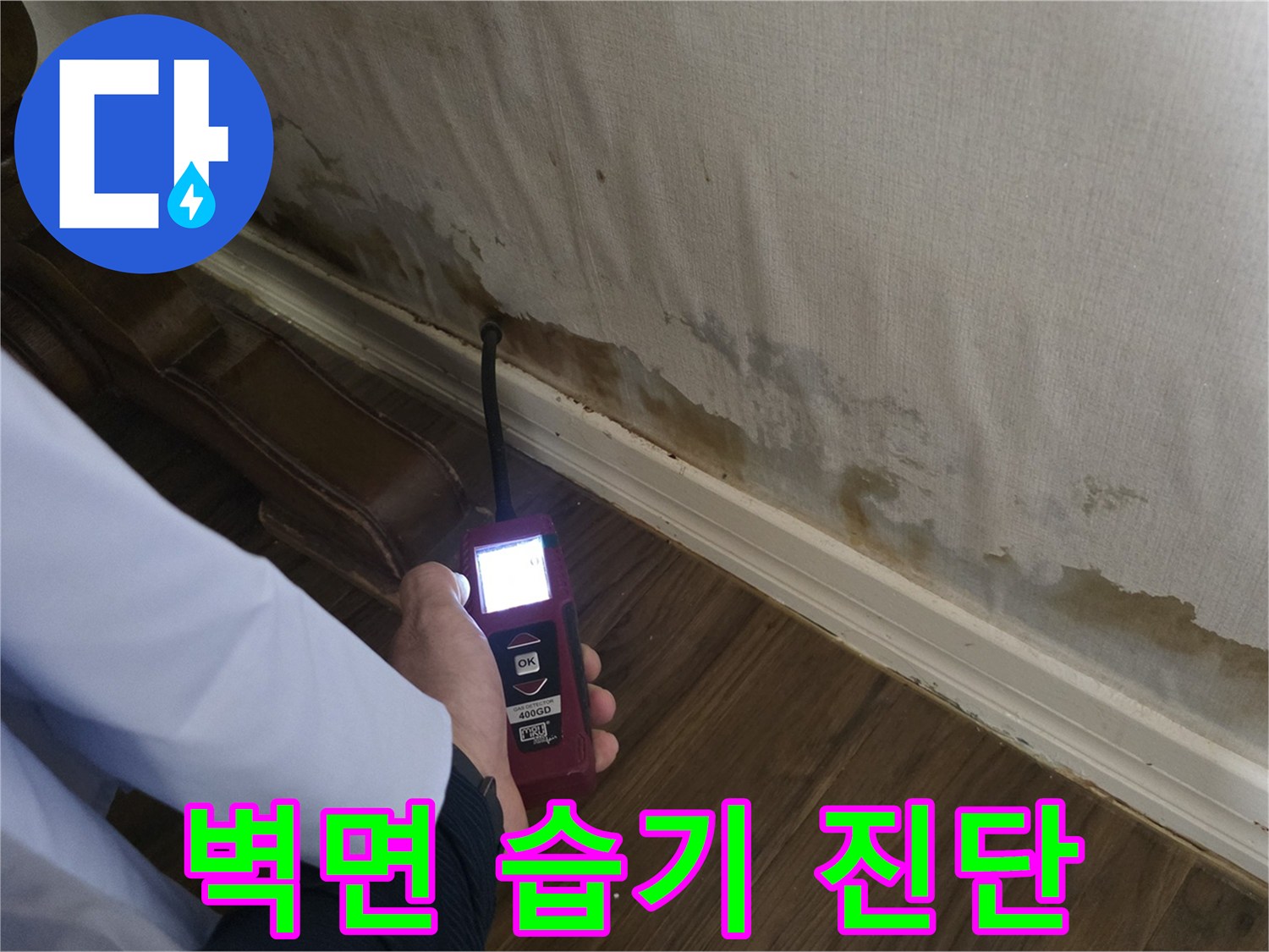 현장 벽면 하단 - 디지털 탐지기로 누수 범위 확인 중