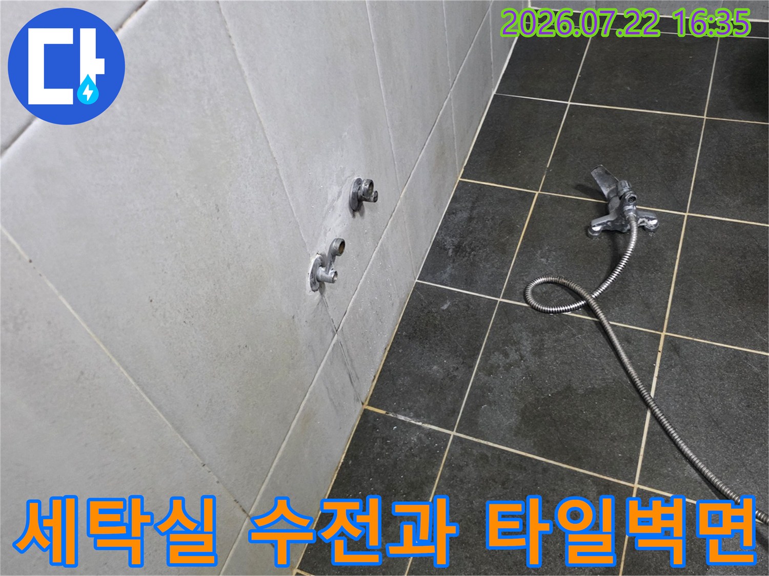회색 타일 벽면에 설치된 두 개의 수도꼭지와 바닥에 놓인 샤워 호스-누수 점검 현장