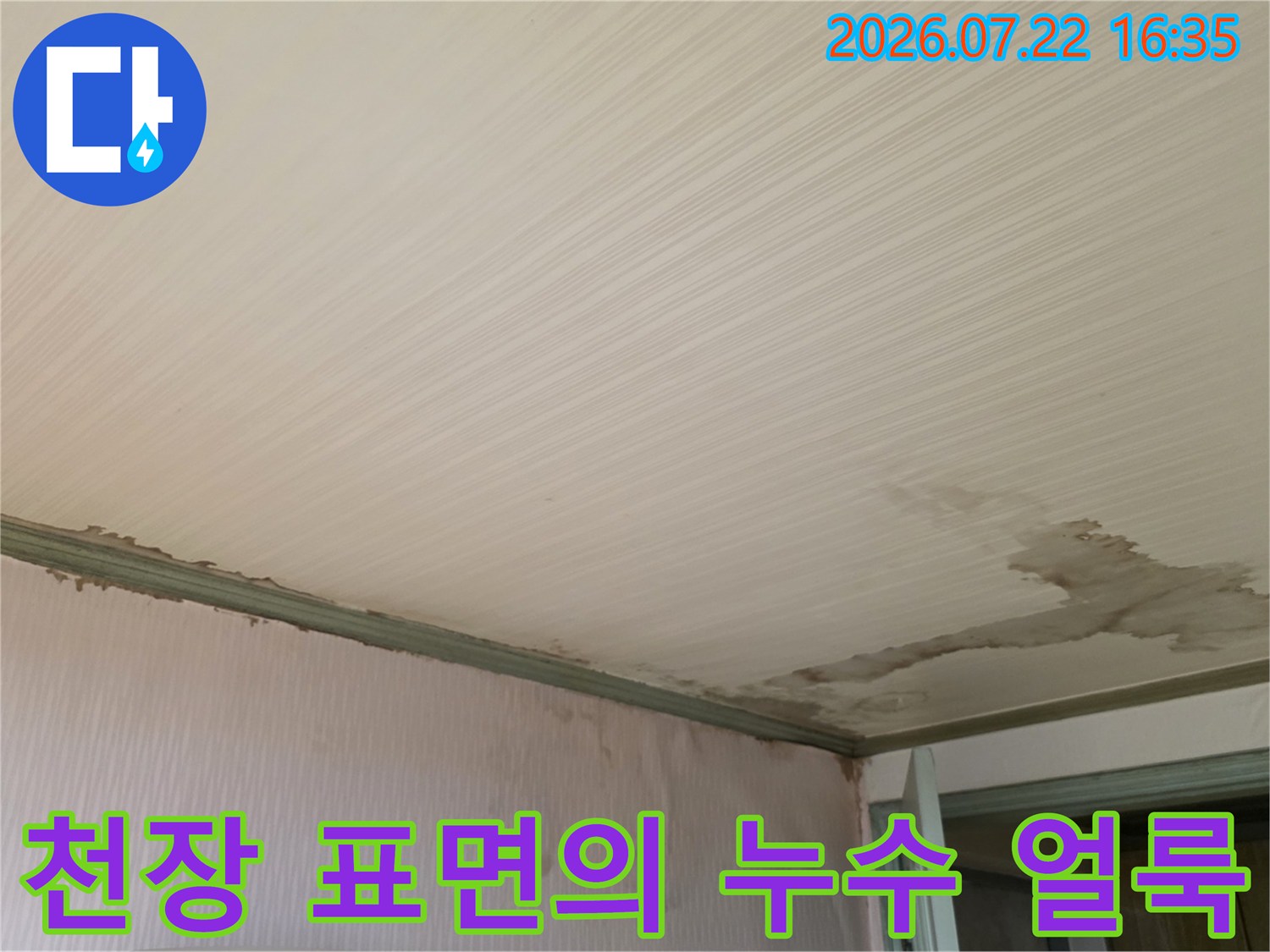 흰색 줄무늬 천장재에 발생한 갈색 누수 얼룩과 습기 자국