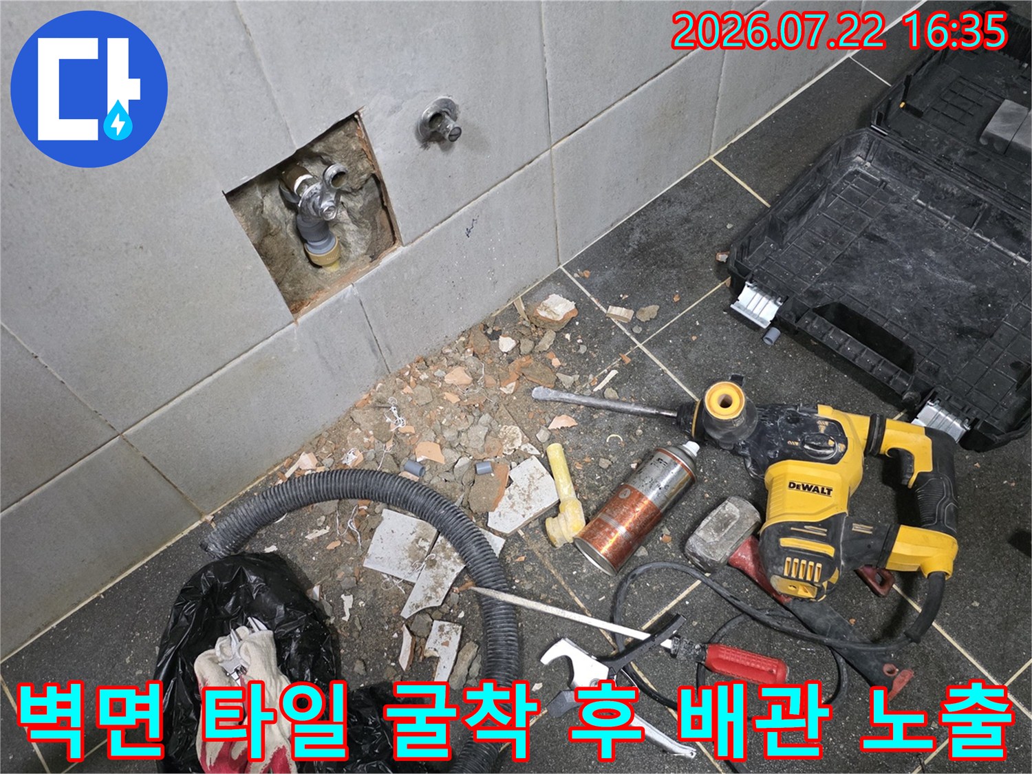 흰색 타일 벽면을 일부 굴착하여 내부에 매립된 수도 배관이 드러난 모습