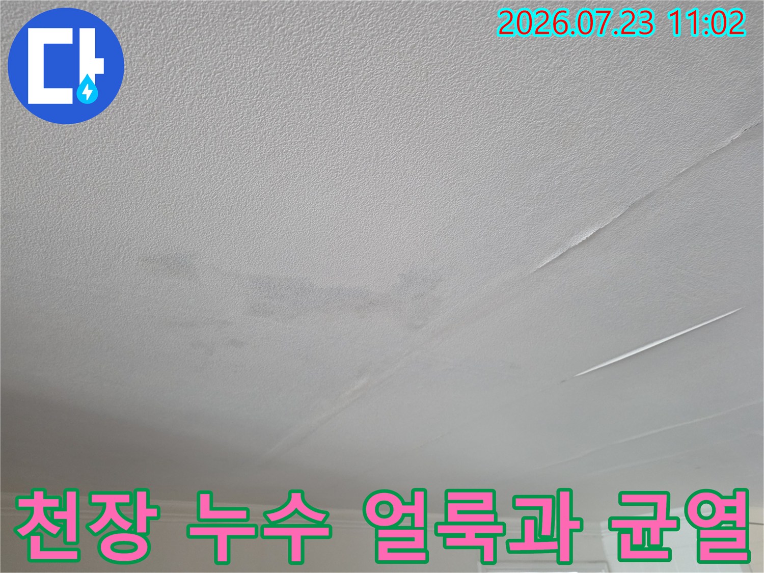 흰색 거실 천장에 발생한 누수 얼룩-그리고 길게 이어진 균열 모습