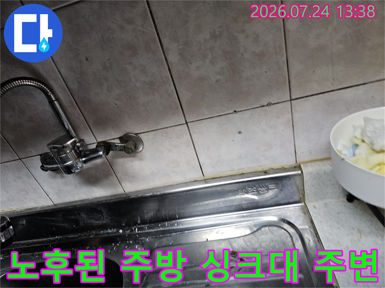 오래된 주방 타일 벽면과 연결된 스테인리스 수전-누수 점검 중