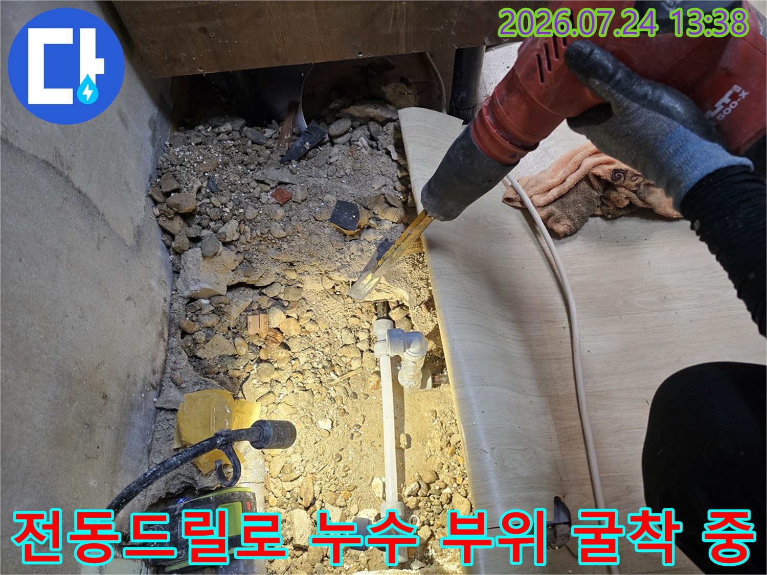 작업자가 보호 장갑을 착용하고 바닥 콘크리트를 뚫어 매립 배관을 찾는 과정