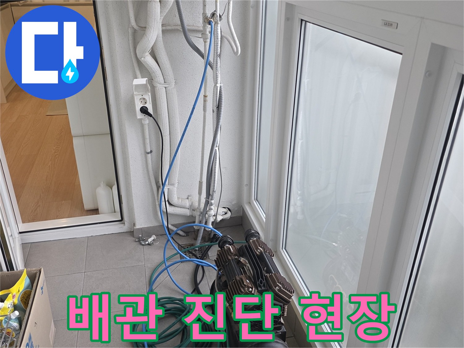 벽면 배관에 연결된 파란색 호스와 압력계 장비