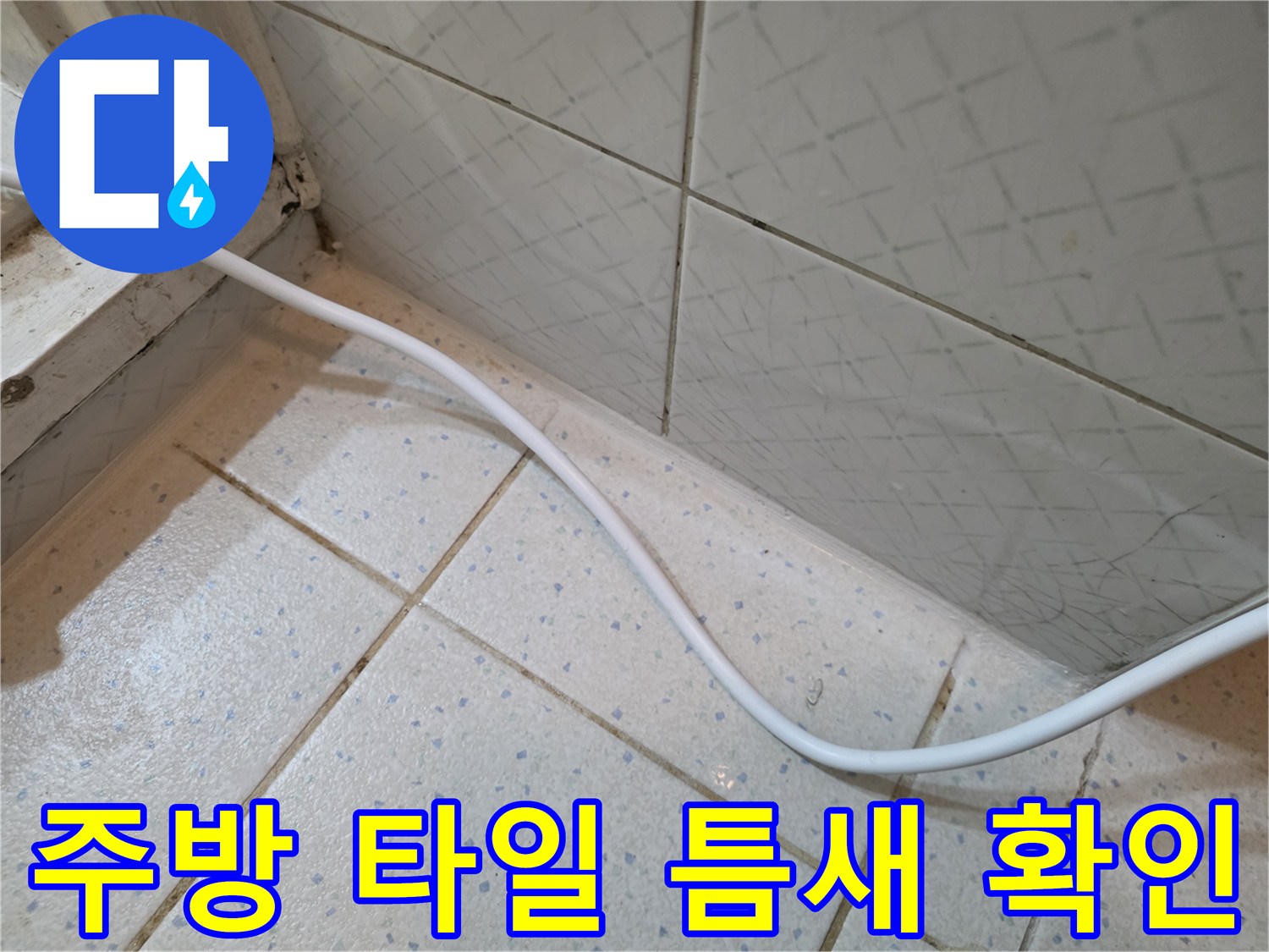 주방 바닥 타일과 벽면 접합부의 상태를 보여주는 사진입니다