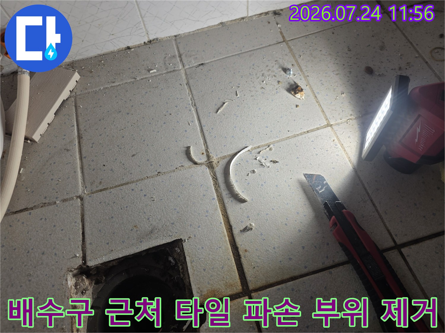 파손된 마감재를 정리하고 배수구 주변 방수 상태를 점검하는 공사 현장
