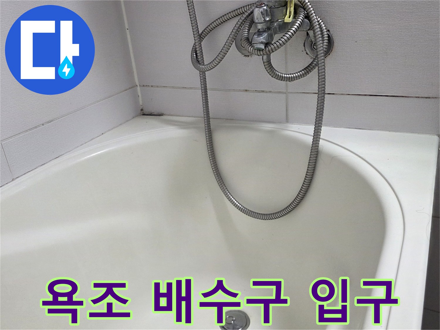 욕조 바닥의 원형 배수구와 샤워기 호스