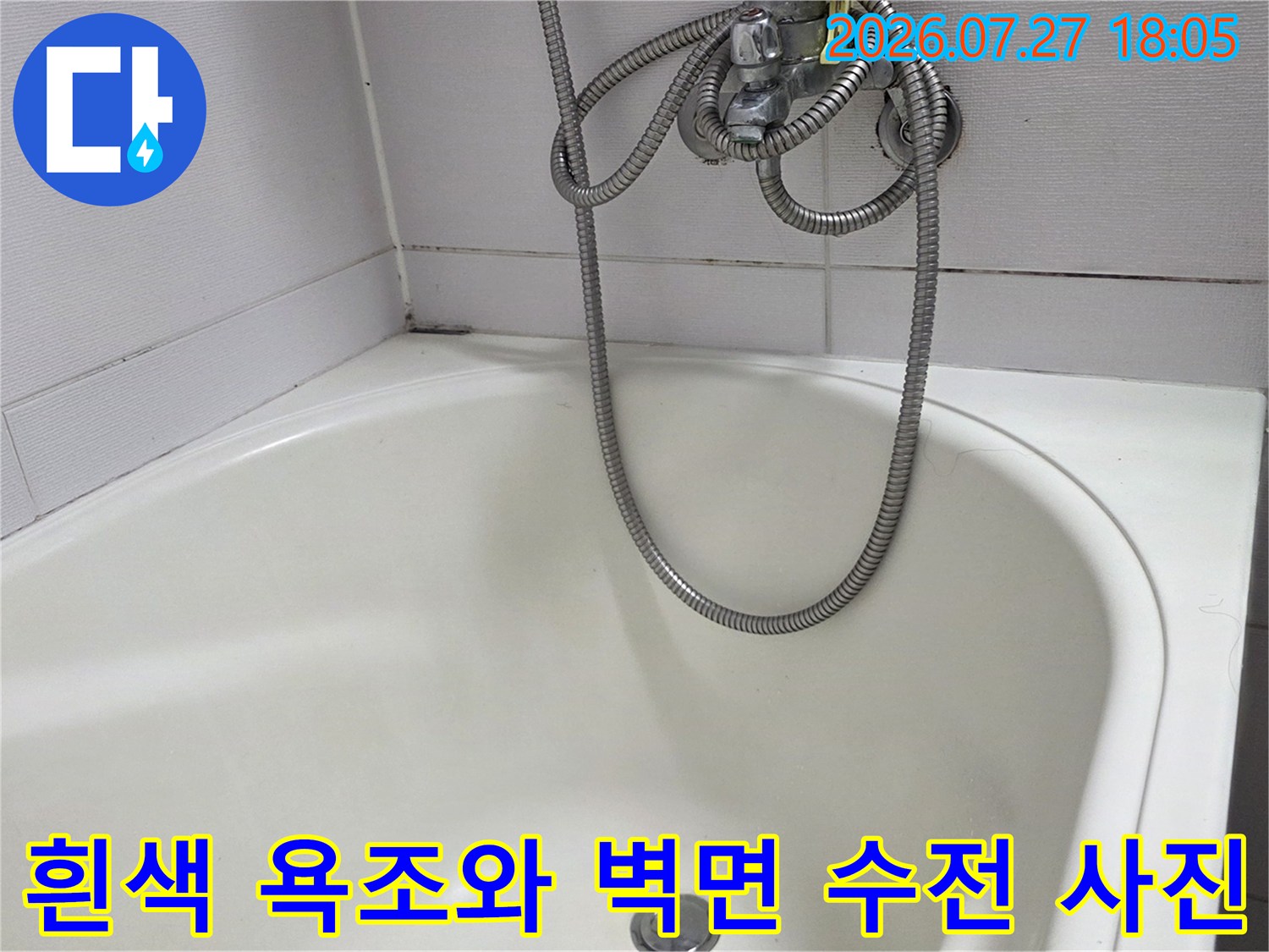 욕조 위로 샤워 호스가 늘어져 있고 흰색 타일이 시공된 화장실 모습
