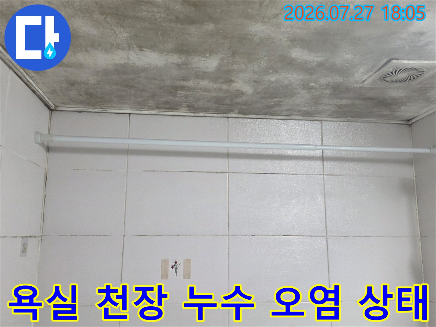 화장실 천장의 환풍기 주변과 표면에 넓게 퍼진 짙은 회색의 누수 얼룩-습기로 인한 변색 현상