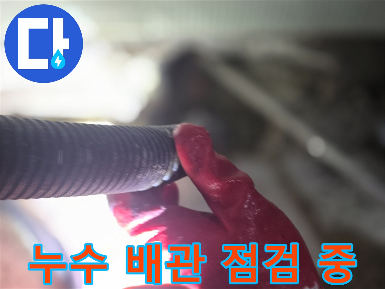 엔지니어가 손으로 배관의 접합부를 면밀히 조사하는 장면입니다.