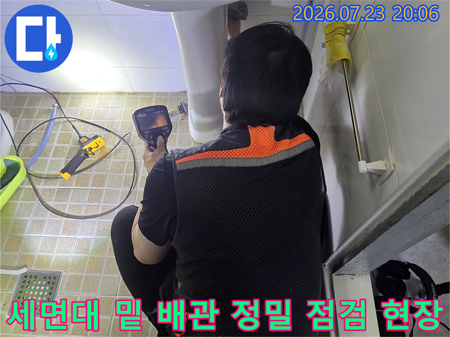 전문가용 장비를 활용하여 세면대 하부의 노출된 배관 상태를 면밀히 조사하는 모습
