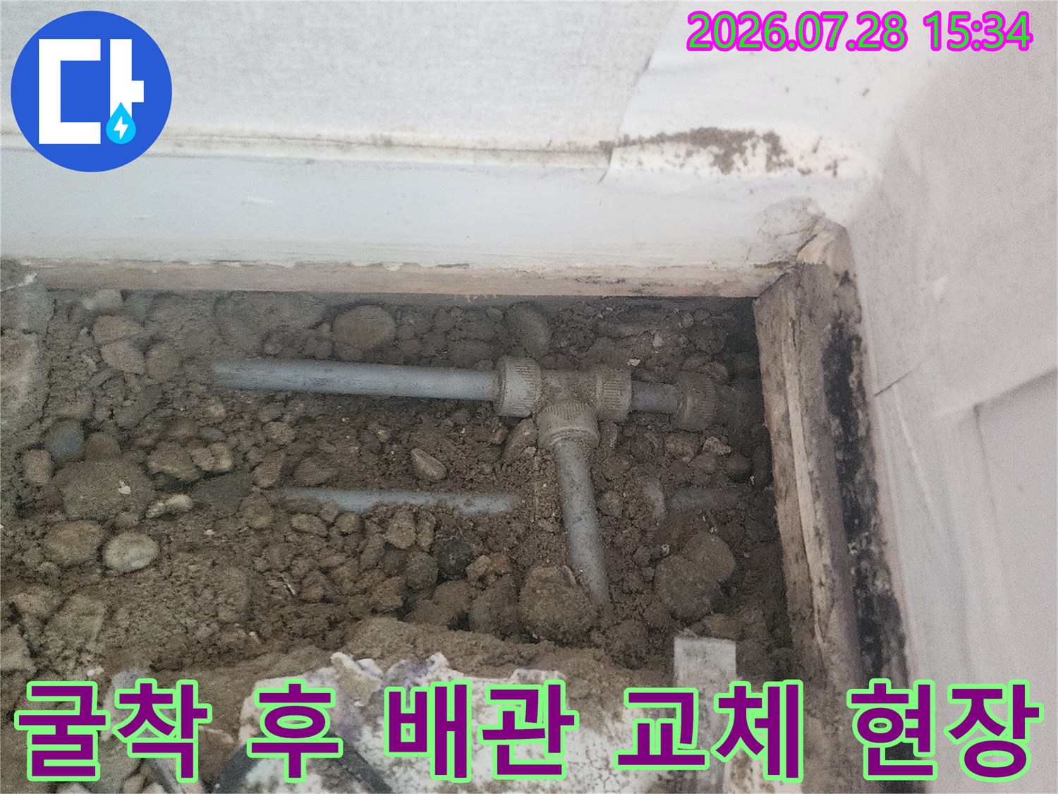 먼지 낀 환경 속에서 노출된 수직 및 수평 배관의 연결부 수리 장면