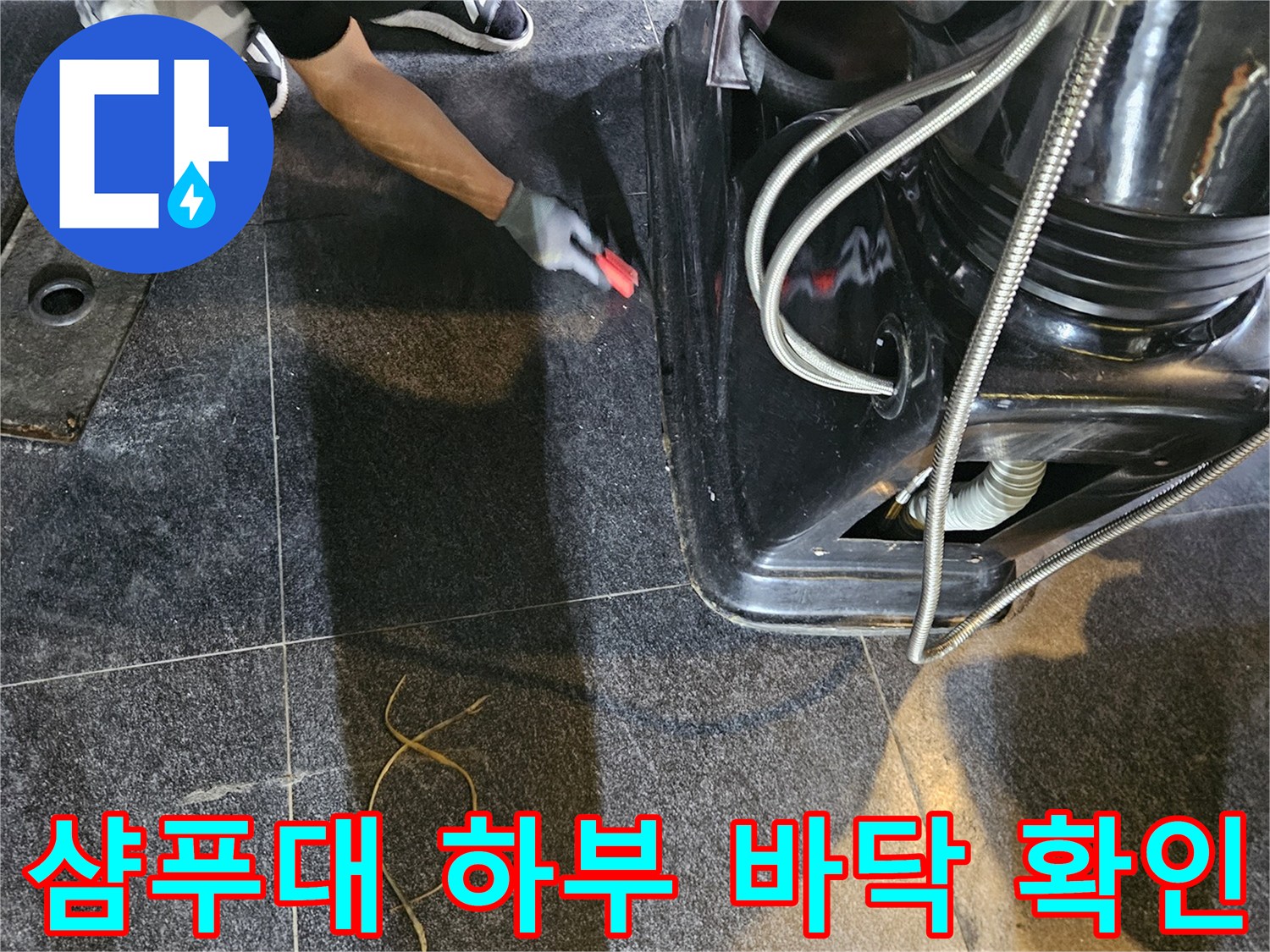 미용실 샴푸대 아래 검은색 타일 바닥과 배관 주변을 점검하는 모습