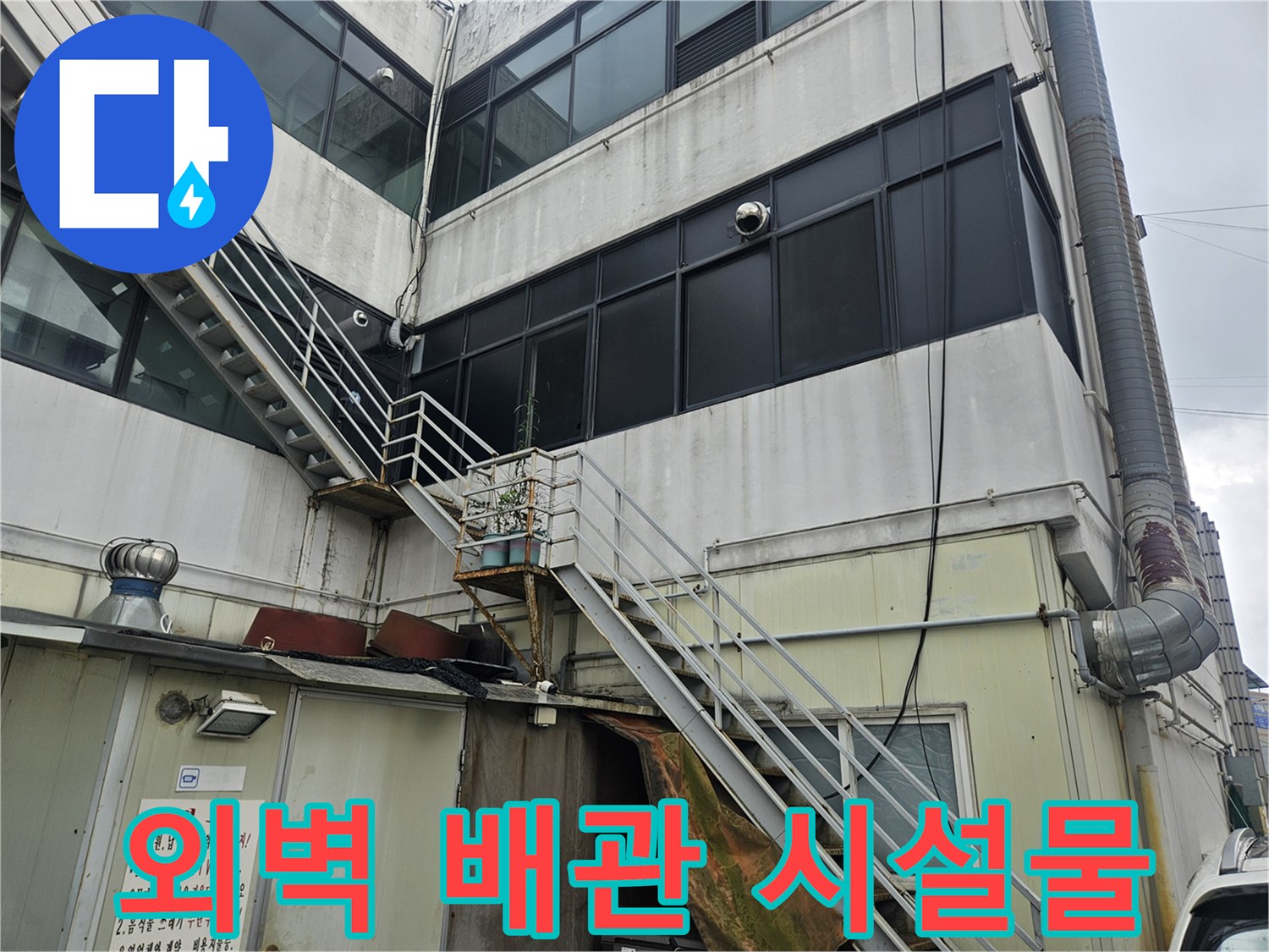상가 외벽의-금속 난간과 노출된 배관 연결 부위