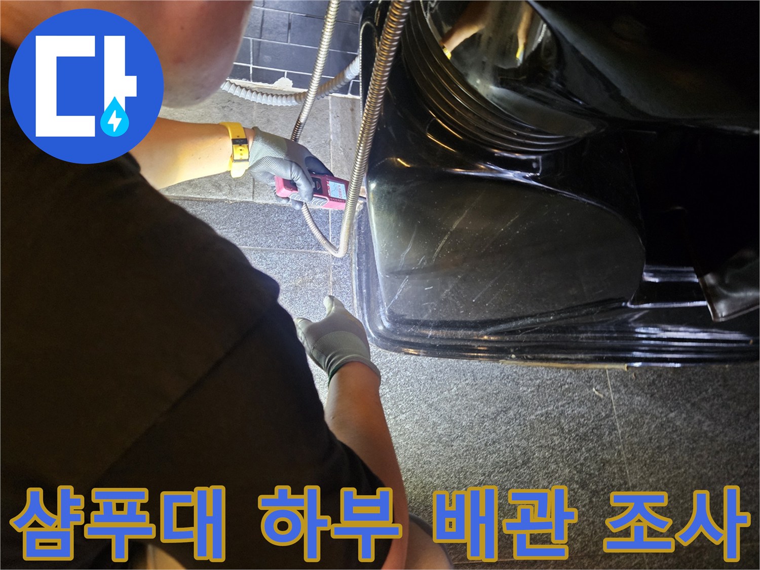 장비를 사용하여 샴푸대 아래 배관의 이상을 확인하는 작업자