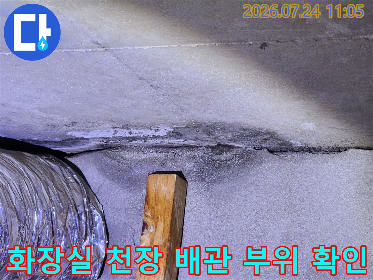 천장 내부의 노출된 배관과 습기로 인한 오염 흔적을 점검하는 모습