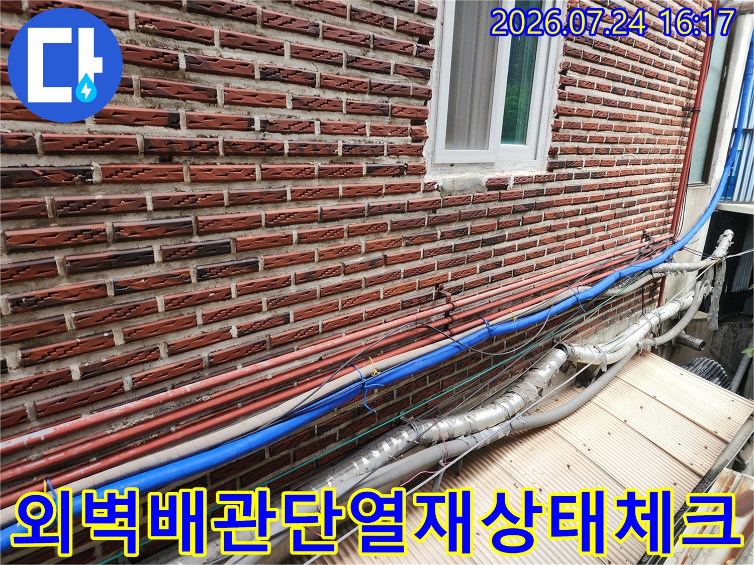 노후된 단열재와 파란색 보온재 배관의 상태를 비교하며 점검하는 모습