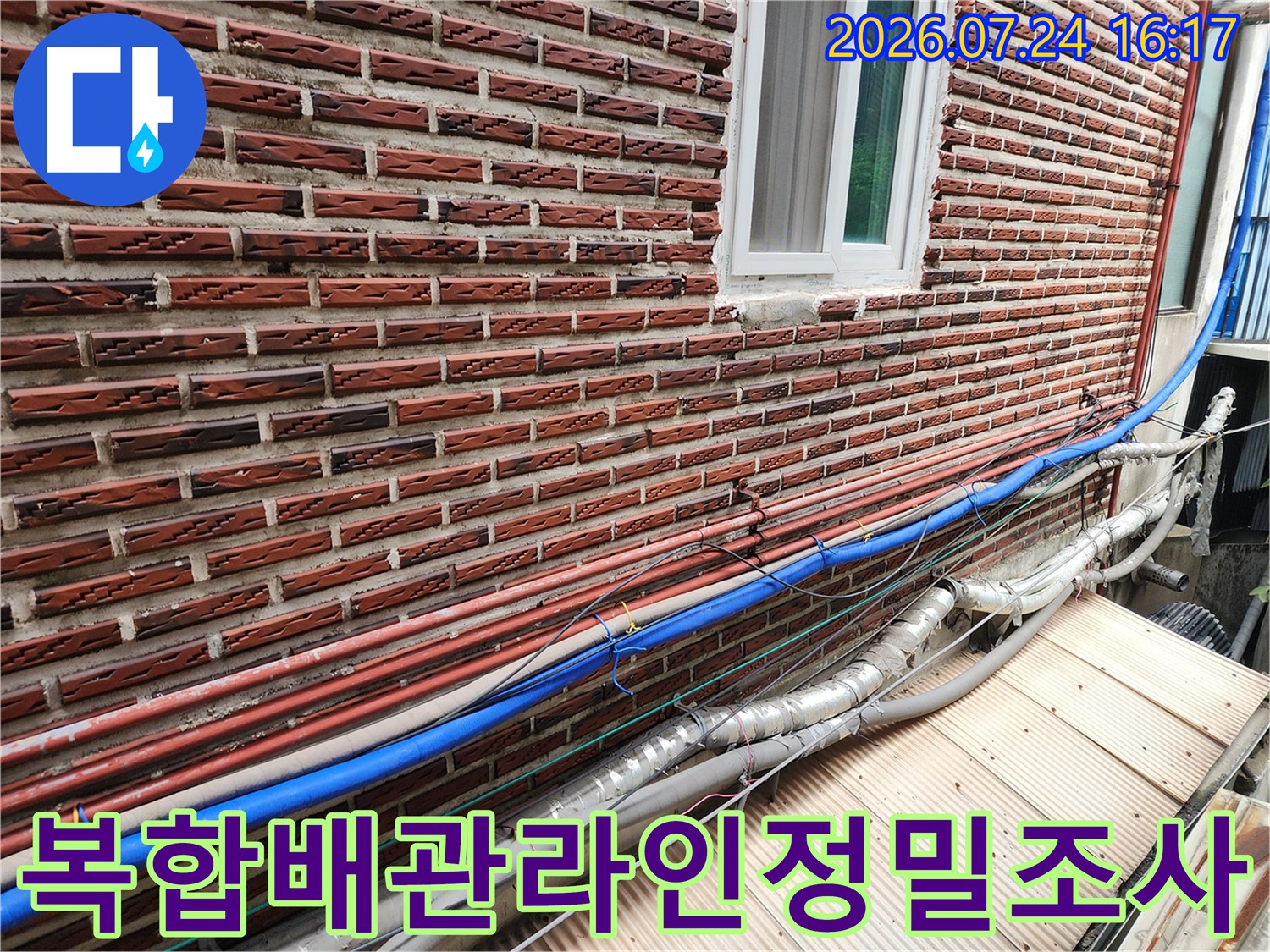 다양한 색상의 배관과 단열재가 섞인 외벽 구간을 상세히 조사하는 모습