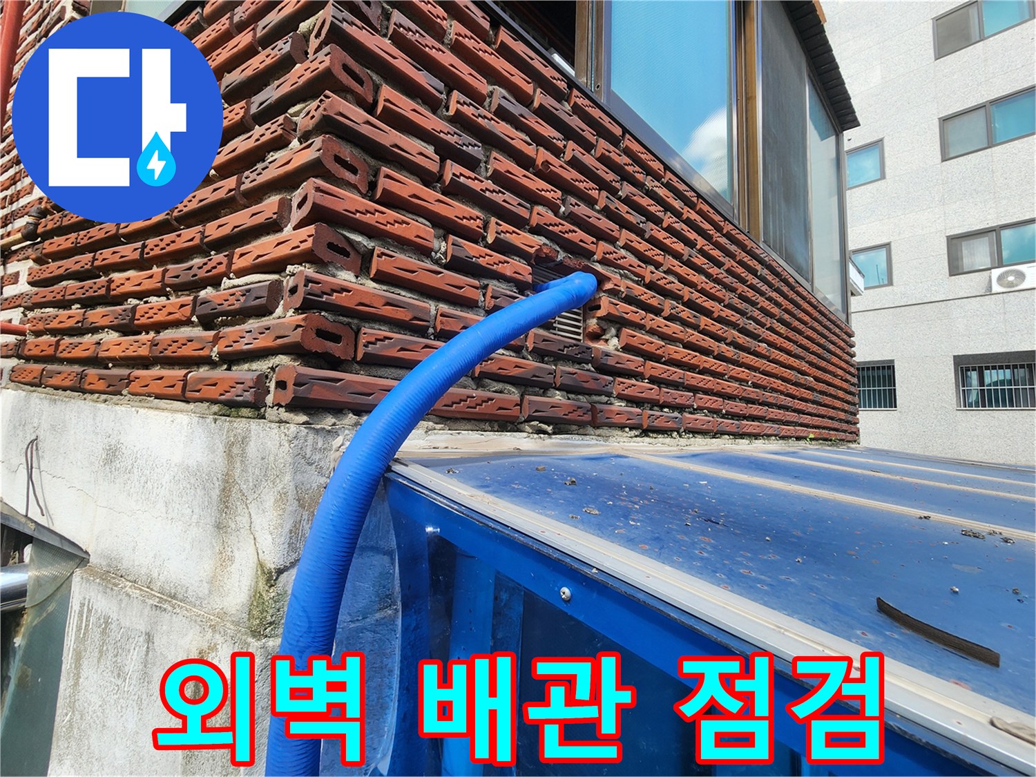 붉은 벽돌 외벽에 설치된 파란색 보온재 배관의 상태 확인