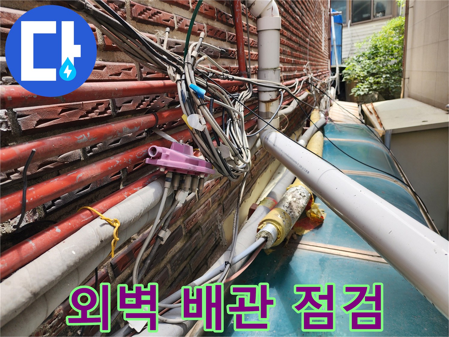 성북구 외벽에 노출된 복잡한 수도 및 온수 배관의 상태를 확인하는 모습