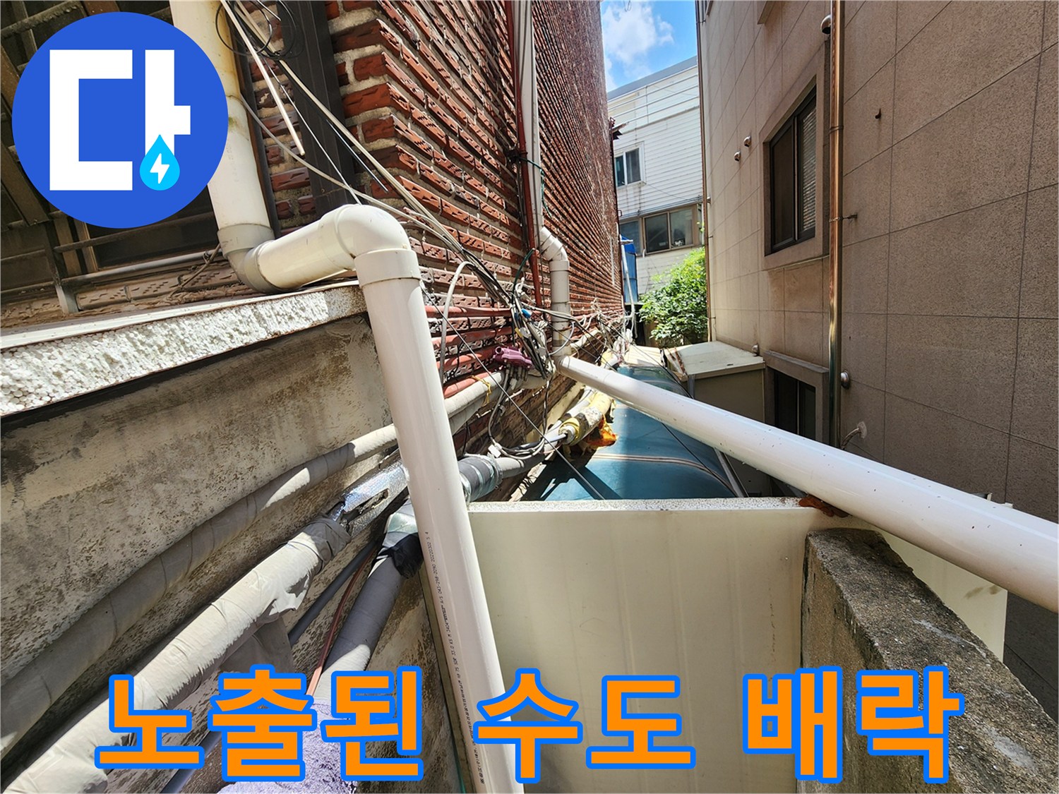 외부로 드러난 흰색 PVC 배관과 벽돌 외벽 구조
