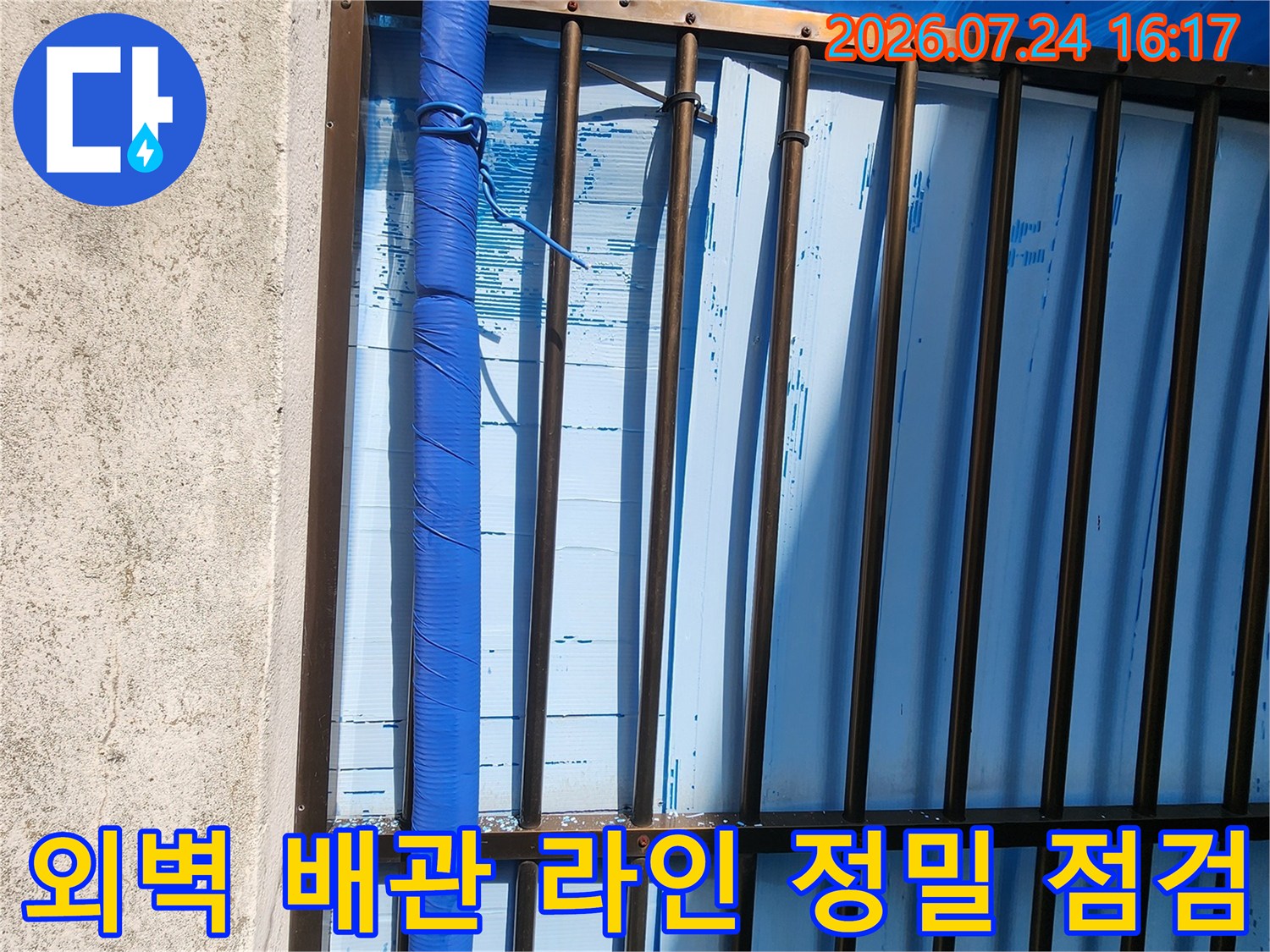 파란색 보온재로 덮여 있는 외부 노출 수도 배관의 상태를 살피는 모습