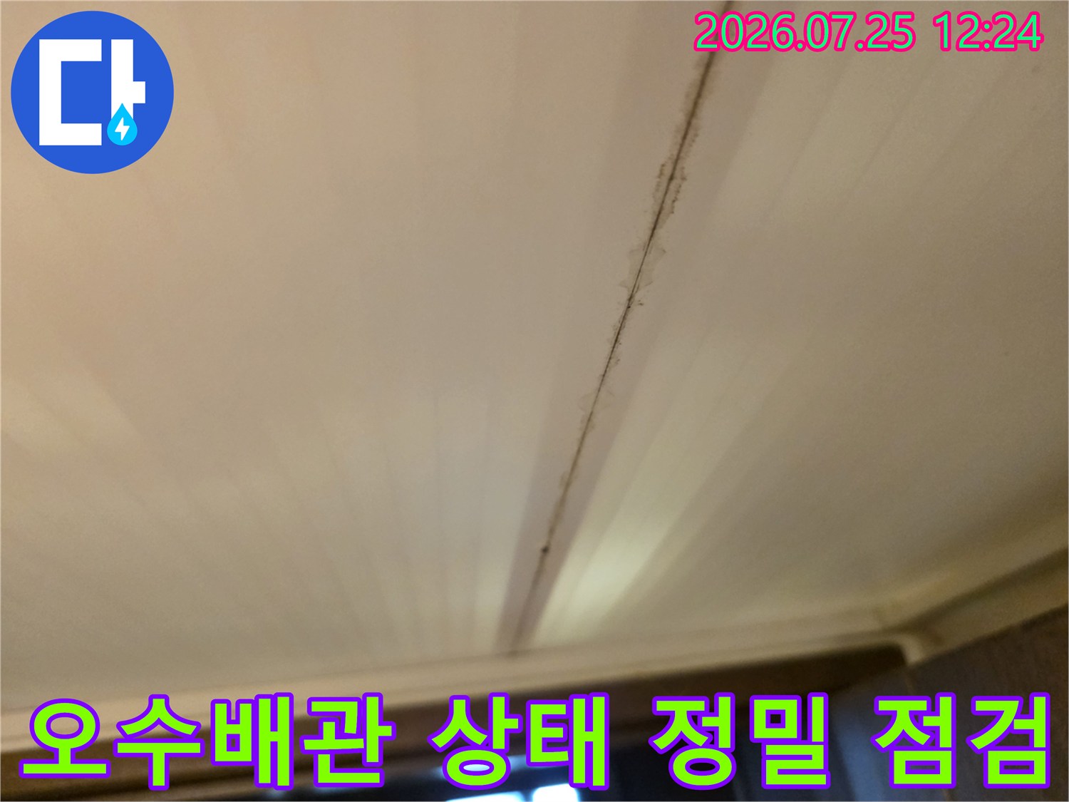 화장실 천장 안쪽의 배관 연결 부위를 상세히 살피는 모습