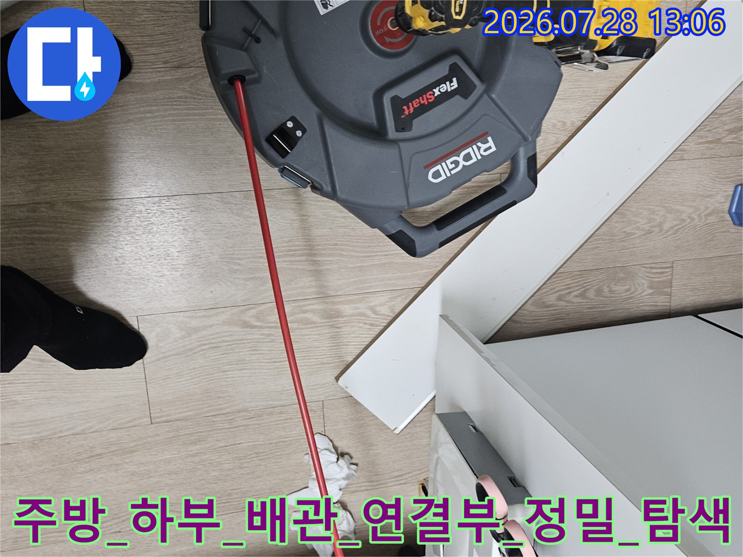전문가용 가스 탐지기를 활용하여 주방 아래쪽 배수 트랩과 연결 부위를 정밀하게 점검하는 장면
