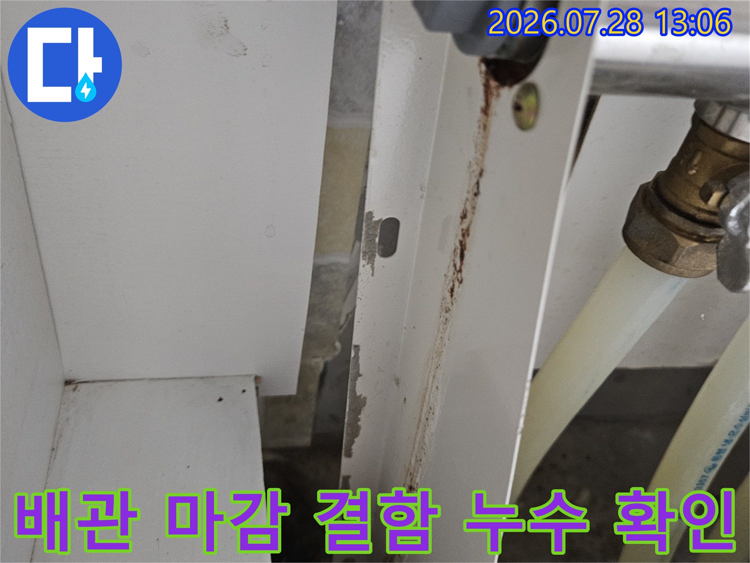 주방 하단 배출 파이프의 연결부 및 마감 상태를 정밀하게 촬영한 사진