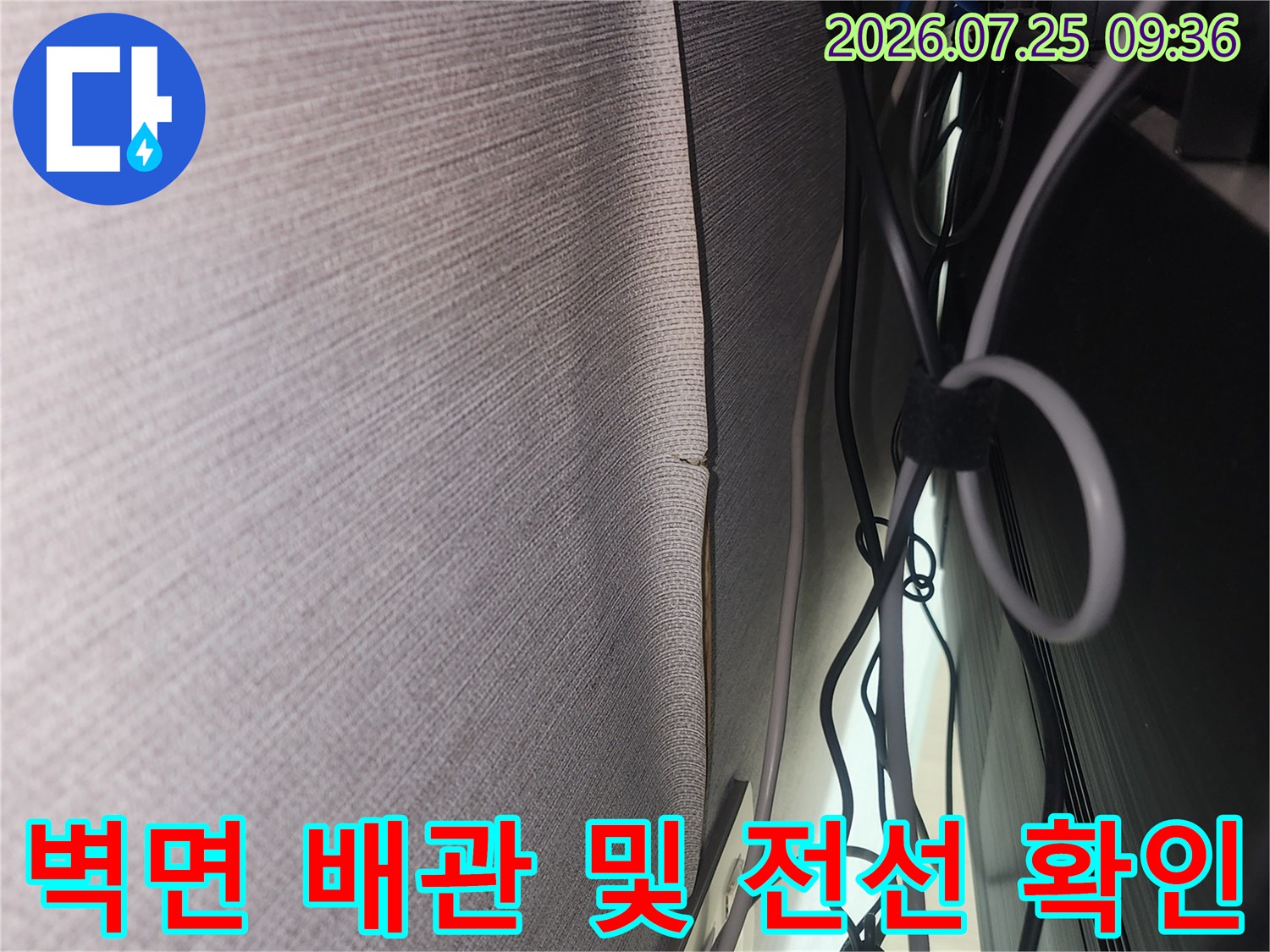 복잡한 전기 선과 수송 배관이 겹쳐진 벽 하단부를 정밀 점검하는 현장