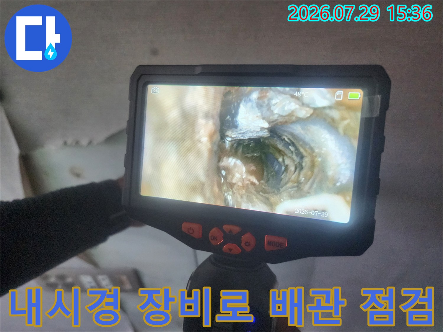 LCD 화면이 달린 내시경 카메라를 사용하여 벽 속 배관의 상태를 정밀하게 확인하는 장면