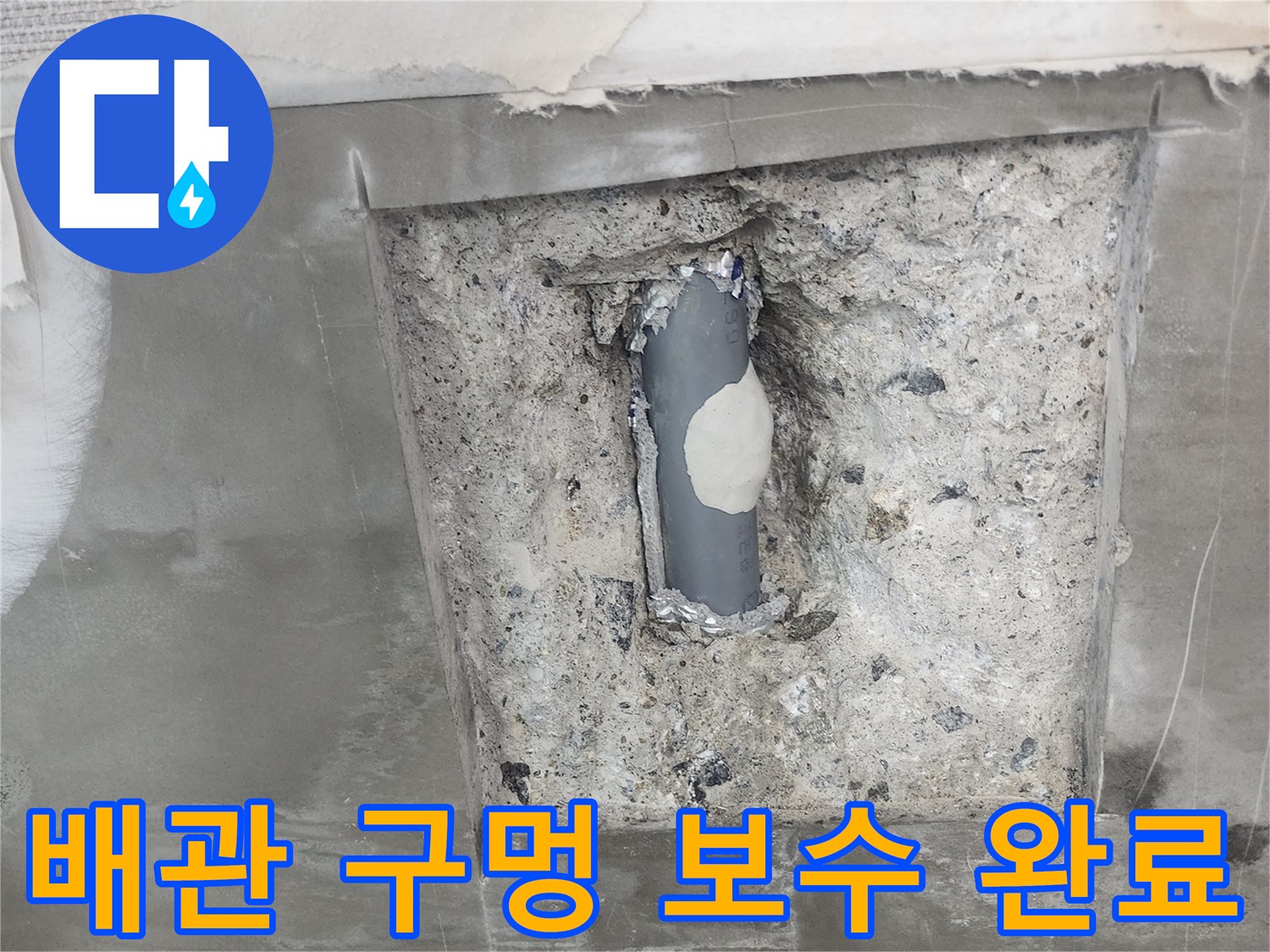 콘크리트 굴착 부위 - 파손된 회색 배관을 보수재로 메꾼 현장 사진입니다.