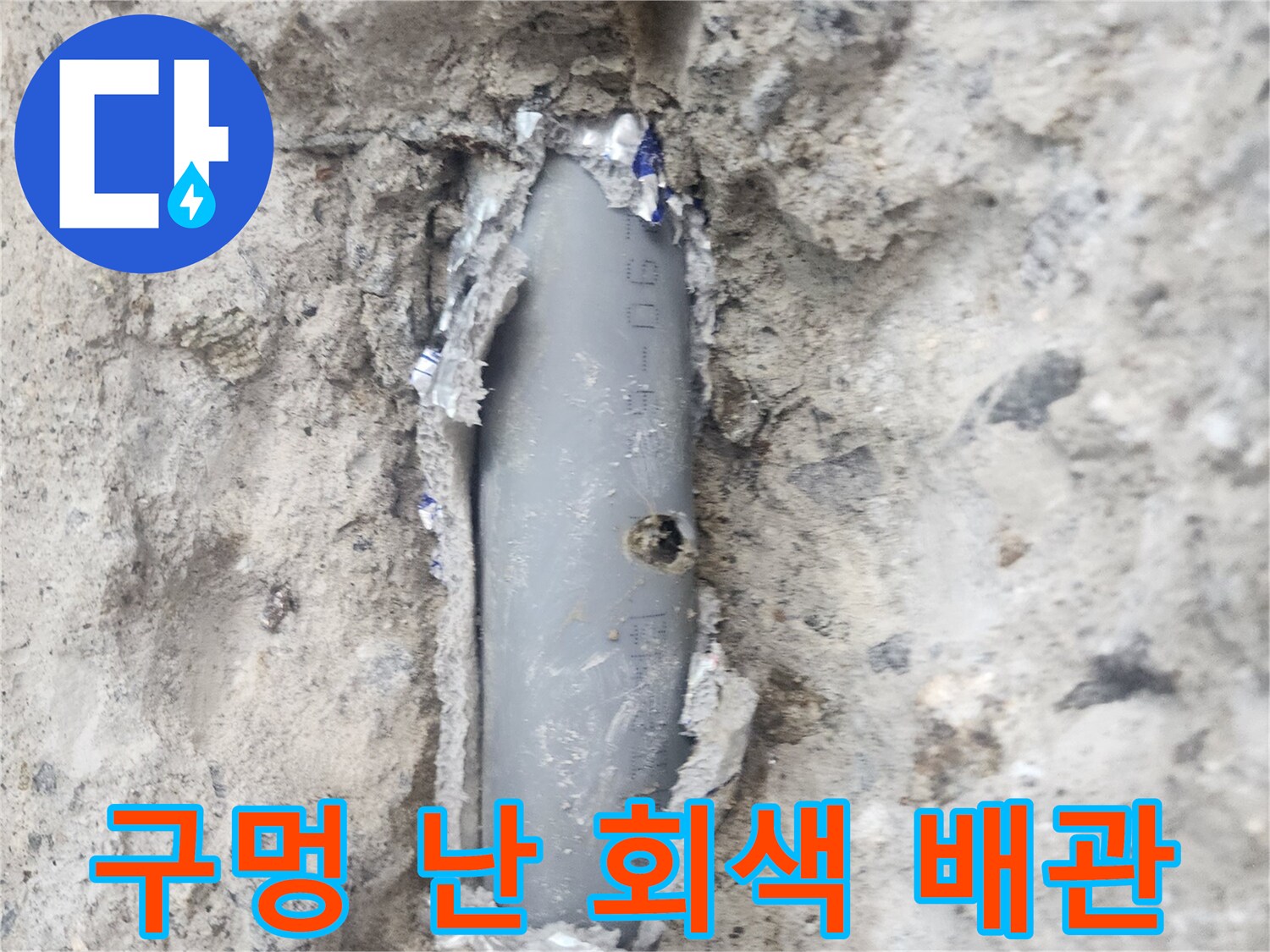 콘크리트 틈 사이로 보이는 구멍 난 배관의 모습