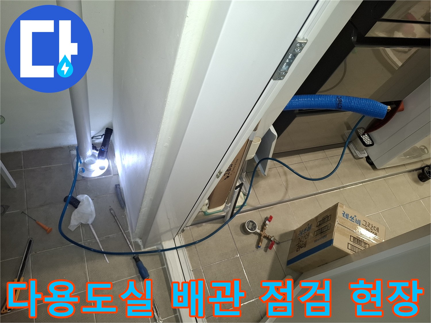 하얀색 수직 배관 주변의 누수 여부를 확인하기 위한 장비 설치 상태