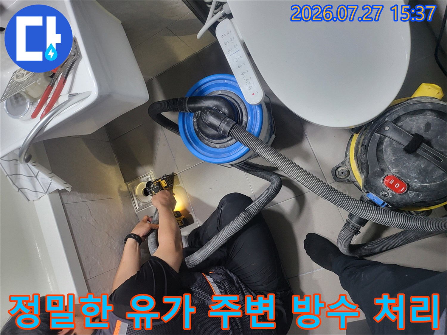 엔지니어가 무릎을 굽히고 앉아 화장실 바닥의 배수구 부분을 전동 도구로 세밀하게 다듬는 모습