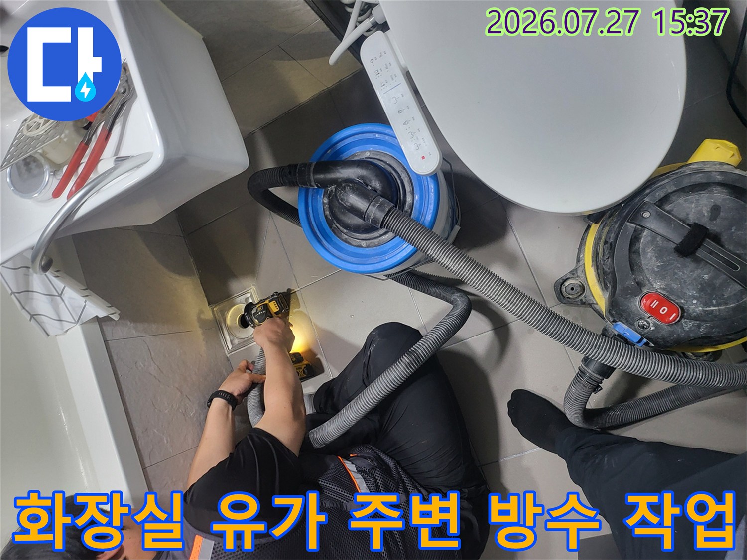 욕실 바닥 배수구-유가 주변을 전동 공구와 진공 청소기를 사용하여 정밀하게 보수하는 모습