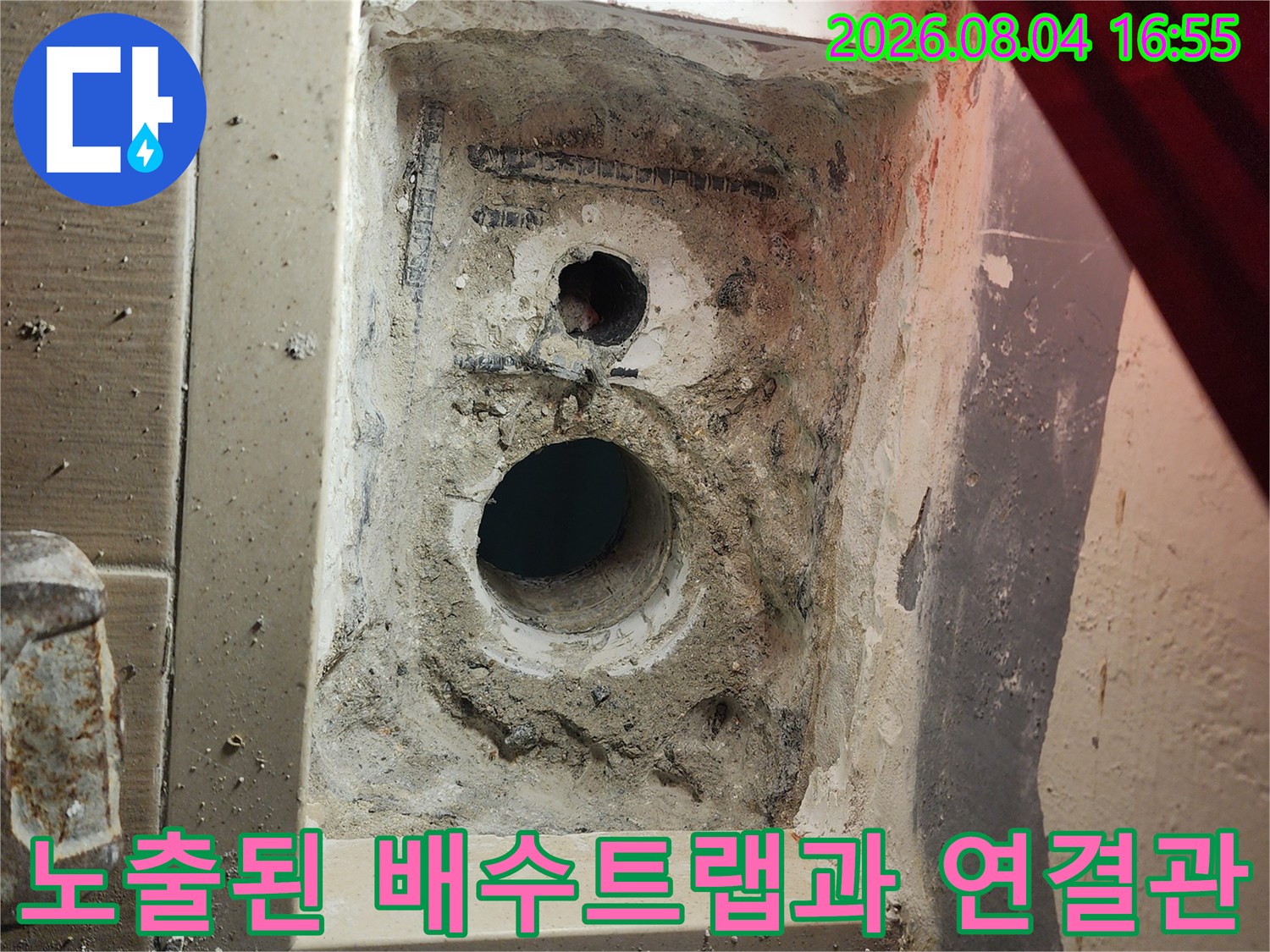 세탁기 아래쪽 바닥을 굴착하여 노출시킨 트랩 및 주변 매립 배관의 상세 사진입니다.